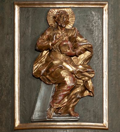 Zdjęcie nr 23: Kosz ambony na rzucie czworoboku, o bokach lekko wypukłych, wsparty na piramidalnym cokole z szyszką ujętą liśćmi. Kosz podzielony szerokimi, kanelowanymi spływami i zwieńczony gzymsem. Na ściance frontowej płaskorzeźbiona figura Chrystusa błogosławiącego trzymany w ręku bochenek chleba. Zaplecek flankowany profilowanymi listwami z kampanulami zakończonymi ulistnionymi konsolkami, pośrodku obraz w kształcie stojącego prostokąta zamkniętego łukiem półkolistym, nadwieszonym z przedstawieniem Jezusa wśród mędrców. Baldachim powielający rzut kosza, profilowany, ujęty impostami, zwieńczony czterema esowato wygiętymi i łączącymi się górą kabłąkami. Na podniebieniu baldachimu gołębica Ducha Świętego ,a tle promieni. Na nich figura Chrystusa Zmartwychwstałego, ukazanego w całej postaci, w kontrapoście, z płaszczem na plecach osłaniającym biodro. Prawą rękę unosi w geście błogosławieństwa, w lewej trzyma chorągiew. 