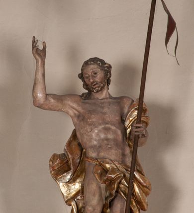 Zdjęcie nr 20: Kosz ambony na rzucie czworoboku, o bokach lekko wypukłych, wsparty na piramidalnym cokole z szyszką ujętą liśćmi. Kosz podzielony szerokimi, kanelowanymi spływami i zwieńczony gzymsem. Na ściance frontowej płaskorzeźbiona figura Chrystusa błogosławiącego trzymany w ręku bochenek chleba. Zaplecek flankowany profilowanymi listwami z kampanulami zakończonymi ulistnionymi konsolkami, pośrodku obraz w kształcie stojącego prostokąta zamkniętego łukiem półkolistym, nadwieszonym z przedstawieniem Jezusa wśród mędrców. Baldachim powielający rzut kosza, profilowany, ujęty impostami, zwieńczony czterema esowato wygiętymi i łączącymi się górą kabłąkami. Na podniebieniu baldachimu gołębica Ducha Świętego ,a tle promieni. Na nich figura Chrystusa Zmartwychwstałego, ukazanego w całej postaci, w kontrapoście, z płaszczem na plecach osłaniającym biodro. Prawą rękę unosi w geście błogosławieństwa, w lewej trzyma chorągiew. 