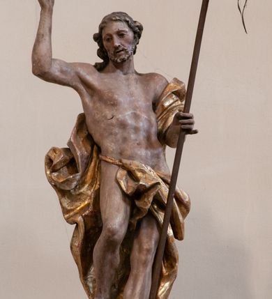 Zdjęcie nr 22: Kosz ambony na rzucie czworoboku, o bokach lekko wypukłych, wsparty na piramidalnym cokole z szyszką ujętą liśćmi. Kosz podzielony szerokimi, kanelowanymi spływami i zwieńczony gzymsem. Na ściance frontowej płaskorzeźbiona figura Chrystusa błogosławiącego trzymany w ręku bochenek chleba. Zaplecek flankowany profilowanymi listwami z kampanulami zakończonymi ulistnionymi konsolkami, pośrodku obraz w kształcie stojącego prostokąta zamkniętego łukiem półkolistym, nadwieszonym z przedstawieniem Jezusa wśród mędrców. Baldachim powielający rzut kosza, profilowany, ujęty impostami, zwieńczony czterema esowato wygiętymi i łączącymi się górą kabłąkami. Na podniebieniu baldachimu gołębica Ducha Świętego ,a tle promieni. Na nich figura Chrystusa Zmartwychwstałego, ukazanego w całej postaci, w kontrapoście, z płaszczem na plecach osłaniającym biodro. Prawą rękę unosi w geście błogosławieństwa, w lewej trzyma chorągiew. 