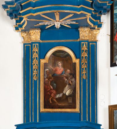 Zdjęcie nr 13: Kosz ambony na rzucie czworoboku, o bokach lekko wypukłych, wsparty na piramidalnym cokole z szyszką ujętą liśćmi. Kosz podzielony szerokimi, kanelowanymi spływami i zwieńczony gzymsem. Na ściance frontowej płaskorzeźbiona figura Chrystusa błogosławiącego trzymany w ręku bochenek chleba. Zaplecek flankowany profilowanymi listwami z kampanulami zakończonymi ulistnionymi konsolkami, pośrodku obraz w kształcie stojącego prostokąta zamkniętego łukiem półkolistym, nadwieszonym z przedstawieniem Jezusa wśród mędrców. Baldachim powielający rzut kosza, profilowany, ujęty impostami, zwieńczony czterema esowato wygiętymi i łączącymi się górą kabłąkami. Na podniebieniu baldachimu gołębica Ducha Świętego ,a tle promieni. Na nich figura Chrystusa Zmartwychwstałego, ukazanego w całej postaci, w kontrapoście, z płaszczem na plecach osłaniającym biodro. Prawą rękę unosi w geście błogosławieństwa, w lewej trzyma chorągiew. 