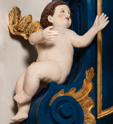 Zdjęcie nr 8: Kosz ambony na rzucie czworoboku, o bokach lekko wypukłych, wsparty na piramidalnym cokole z szyszką ujętą liśćmi. Kosz podzielony szerokimi, kanelowanymi spływami i zwieńczony gzymsem. Na ściance frontowej płaskorzeźbiona figura Chrystusa błogosławiącego trzymany w ręku bochenek chleba. Zaplecek flankowany profilowanymi listwami z kampanulami zakończonymi ulistnionymi konsolkami, pośrodku obraz w kształcie stojącego prostokąta zamkniętego łukiem półkolistym, nadwieszonym z przedstawieniem Jezusa wśród mędrców. Baldachim powielający rzut kosza, profilowany, ujęty impostami, zwieńczony czterema esowato wygiętymi i łączącymi się górą kabłąkami. Na podniebieniu baldachimu gołębica Ducha Świętego ,a tle promieni. Na nich figura Chrystusa Zmartwychwstałego, ukazanego w całej postaci, w kontrapoście, z płaszczem na plecach osłaniającym biodro. Prawą rękę unosi w geście błogosławieństwa, w lewej trzyma chorągiew. 