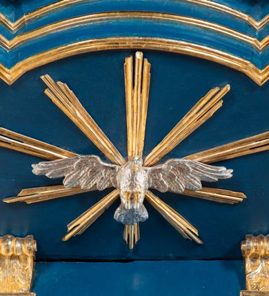 Zdjęcie nr 31: Kosz ambony na rzucie czworoboku, o bokach lekko wypukłych, wsparty na piramidalnym cokole z szyszką ujętą liśćmi. Kosz podzielony szerokimi, kanelowanymi spływami i zwieńczony gzymsem. Na ściance frontowej płaskorzeźbiona figura Chrystusa błogosławiącego trzymany w ręku bochenek chleba. Zaplecek flankowany profilowanymi listwami z kampanulami zakończonymi ulistnionymi konsolkami, pośrodku obraz w kształcie stojącego prostokąta zamkniętego łukiem półkolistym, nadwieszonym z przedstawieniem Jezusa wśród mędrców. Baldachim powielający rzut kosza, profilowany, ujęty impostami, zwieńczony czterema esowato wygiętymi i łączącymi się górą kabłąkami. Na podniebieniu baldachimu gołębica Ducha Świętego ,a tle promieni. Na nich figura Chrystusa Zmartwychwstałego, ukazanego w całej postaci, w kontrapoście, z płaszczem na plecach osłaniającym biodro. Prawą rękę unosi w geście błogosławieństwa, w lewej trzyma chorągiew. 