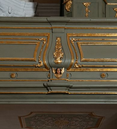 Zdjęcie nr 6: Prospekt organowy jest dwuczęściowy, czterowieżowy, zbudowany na wysokim cokole, o ośmiu rejestrach. Każda z części prospektu jest ujęta parą złoconych kolumn korynckich, stojących na ukośnie dostawionych postumentach z wolutowymi impostami. Kolumny podtrzymują spływy wolutowe zakończone wazonami płomienistymi (skrajne wieże), lub wybrzuszone łuki odcinkowe zakończone motywem rocaille&#039;m (wewnętrzne wieże). Cztery największe rejestry przysłonięte pozłacanymi kotarami. Kontuar wolnostojący, pomiędzy obiema częściami szafy organowej, na osi założenia.