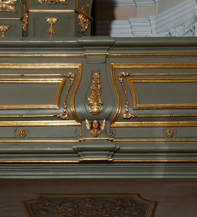 Zdjęcie nr 7: Prospekt organowy jest dwuczęściowy, czterowieżowy, zbudowany na wysokim cokole, o ośmiu rejestrach. Każda z części prospektu jest ujęta parą złoconych kolumn korynckich, stojących na ukośnie dostawionych postumentach z wolutowymi impostami. Kolumny podtrzymują spływy wolutowe zakończone wazonami płomienistymi (skrajne wieże), lub wybrzuszone łuki odcinkowe zakończone motywem rocaille'm (wewnętrzne wieże). Cztery największe rejestry przysłonięte pozłacanymi kotarami. Kontuar wolnostojący, pomiędzy obiema częściami szafy organowej, na osi założenia.