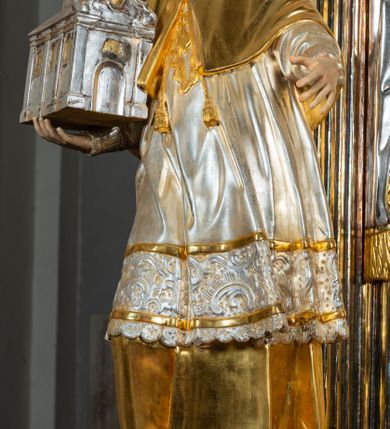 Zdjęcie nr 3: Ołtarz drewniany, prostopadłościenny z kamienną mensą, z kamiennym portatylem. Antepedium drewniane ujęte marmoryzowaną ramą z karbowanym profilem. W polu owalny medalion z przedstawieniem świętego z zakonu Marków, ujętym wicią akantową przeplatana z kwiatową. Nastawa ołtarzowa architektoniczna, jednoosiowa, jednokondygnacyjna ze zwieńczeniem na cokole.  Retabulum flankowane parą zdwojonych półfilarów zakończonych konsolami,  dźwigających pełne belkowanie oraz fragmenty przerwanego, półkolistego przyczółka z siedzącymi puttami. Na tle pilastrów, na konsolach ustawione figury dwóch świętych. Trzony pilastrów dekorowane kampanulami. W polu środkowym wnęka w formie stojącego prostokąta zamkniętego łukiem segmentowym nadwieszonego z uskokiem ujęta profilowaną ramą, z obrazem Wskrzeszenie Łazarza, w osobnej ramie. Nad wnęką baldachim dekorowany lambrekinem, z podwieszoną tkaniną po dwóch stronach, lamowaną frędzlą. Nam baldachimem kartusz z uskrzydlonymi główkami anielskimi i zwieńczony koroną. Zwieńczenie w formie zbliżonej do trapezu o wklęsłych bokach zamknięte falistym gzymsem, dekorowanym kampanulami. W polu gorejące serce przebite mieczem, w otoku z obłoków i uskrzydlonych główek anielskich, w glorii promienistej.  Struktura polichromowana w sposób imitujący marmoryzację w kolorze beżowo-zielonym. Ornamentyka i profile złocone, detal i zwieńczenie srebrzone.