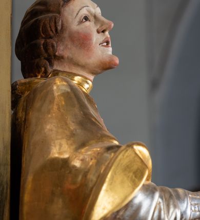 Zdjęcie nr 48: Ołtarz drewniany, prostopadłościenny z kamienną mensą, z kamiennym portatylem. Antepedium drewniane ujęte marmoryzowaną ramą z karbowanym profilem. W polu owalny medalion z przedstawieniem świętego z zakonu Marków, ujętym wicią akantową przeplatana z kwiatową. Nastawa ołtarzowa architektoniczna, jednoosiowa, jednokondygnacyjna ze zwieńczeniem na cokole.  Retabulum flankowane parą zdwojonych półfilarów zakończonych konsolami,  dźwigających pełne belkowanie oraz fragmenty przerwanego, półkolistego przyczółka z siedzącymi puttami. Na tle pilastrów, na konsolach ustawione figury dwóch świętych. Trzony pilastrów dekorowane kampanulami. W polu środkowym wnęka w formie stojącego prostokąta zamkniętego łukiem segmentowym nadwieszonego z uskokiem ujęta profilowaną ramą, z obrazem Wskrzeszenie Łazarza, w osobnej ramie. Nad wnęką baldachim dekorowany lambrekinem, z podwieszoną tkaniną po dwóch stronach, lamowaną frędzlą. Nam baldachimem kartusz z uskrzydlonymi główkami anielskimi i zwieńczony koroną. Zwieńczenie w formie zbliżonej do trapezu o wklęsłych bokach zamknięte falistym gzymsem, dekorowanym kampanulami. W polu gorejące serce przebite mieczem, w otoku z obłoków i uskrzydlonych główek anielskich, w glorii promienistej.  Struktura polichromowana w sposób imitujący marmoryzację w kolorze beżowo-zielonym. Ornamentyka i profile złocone, detal i zwieńczenie srebrzone.