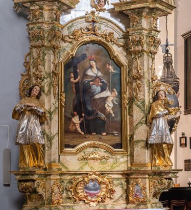 Zdjęcie nr 1: Ołtarz drewniany, prostopadłościenny z kamienną mensą, z kamiennym portatylem. Antepedium z prostokątną płyciną ujętą marmoryzowaną ramą ze złoconym karbowanym profilem. W polu przedstawienie świętej z aniołkiem podającym jej kosz kwiatów, flankowany akantową wicią akantową przeplataną z roślinną, na jasnoniebieskim tle, z datą „1754”. Nastawa ołtarzowa architektoniczna, jednoosiowa, jednokondygnacyjna ze zwieńczeniem na dwustrefowym cokole.  Retabulum flankowane parą opilastrowanych filarów, które dźwigają imposty oraz fragmenty przerwanego półkolistego przyczółka z siedzącymi puttami. Na tle filarów, na konsolach ustawione 2 figury św. Demetriusza i św. Selencjusza. Trzony pilastrów dekorowane zwisami kwiatowymi. W Polu środkowym wnęka w formie stojącego prostokąta zamkniętego łukiem segmentowym nadwieszonego z uskokiem ujęta profilowaną ramą, dekorowaną ornamentem roślinnym, z obrazem św. Heleny. Wnęka od dołu i góry flankowana ornamentem roślinnym i roccailem. Kondygnacja flankowana uszami utworzonymi z roccailu. Zwieńczenie w formie zbliżonej do trapezu o wklęsłych bokach zamknięte fragmentem gzymsu, wyłamanego na kształt łuku segmentowego nadwieszonego, z kartuszem z ornamentem roccailowym. W polu gorejące serce w otoku z obłoków i uskrzydlonych główek anielskich, w glorii promienistej.  Struktura polichromowana w sposób imitujący marmoryzację w kolorze beżowo-zielonym. Ornamentyka i profile złocone, detal i zwieńczenie srebrzone.