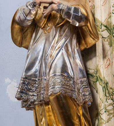 Zdjęcie nr 5: Ołtarz drewniany, prostopadłościenny z kamienną mensą, z kamiennym portatylem. Antepedium z prostokątną płyciną ujętą marmoryzowaną ramą ze złoconym karbowanym profilem. W polu przedstawienie świętej z aniołkiem podającym jej kosz kwiatów, flankowany akantową wicią akantową przeplataną z roślinną, na jasnoniebieskim tle, z datą „1754”. Nastawa ołtarzowa architektoniczna, jednoosiowa, jednokondygnacyjna ze zwieńczeniem na dwustrefowym cokole.  Retabulum flankowane parą opilastrowanych filarów, które dźwigają imposty oraz fragmenty przerwanego półkolistego przyczółka z siedzącymi puttami. Na tle filarów, na konsolach ustawione 2 figury św. Demetriusza i św. Selencjusza. Trzony pilastrów dekorowane zwisami kwiatowymi. W Polu środkowym wnęka w formie stojącego prostokąta zamkniętego łukiem segmentowym nadwieszonego z uskokiem ujęta profilowaną ramą, dekorowaną ornamentem roślinnym, z obrazem św. Heleny. Wnęka od dołu i góry flankowana ornamentem roślinnym i roccailem. Kondygnacja flankowana uszami utworzonymi z roccailu. Zwieńczenie w formie zbliżonej do trapezu o wklęsłych bokach zamknięte fragmentem gzymsu, wyłamanego na kształt łuku segmentowego nadwieszonego, z kartuszem z ornamentem roccailowym. W polu gorejące serce w otoku z obłoków i uskrzydlonych główek anielskich, w glorii promienistej.  Struktura polichromowana w sposób imitujący marmoryzację w kolorze beżowo-zielonym. Ornamentyka i profile złocone, detal i zwieńczenie srebrzone.