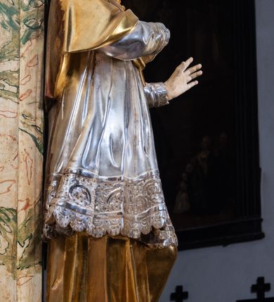 Zdjęcie nr 6: Ołtarz drewniany, prostopadłościenny z kamienną mensą, z kamiennym portatylem. Antepedium z prostokątną płyciną ujętą marmoryzowaną ramą ze złoconym karbowanym profilem. W polu przedstawienie świętej z aniołkiem podającym jej kosz kwiatów, flankowany akantową wicią akantową przeplataną z roślinną, na jasnoniebieskim tle, z datą „1754”. Nastawa ołtarzowa architektoniczna, jednoosiowa, jednokondygnacyjna ze zwieńczeniem na dwustrefowym cokole.  Retabulum flankowane parą opilastrowanych filarów, które dźwigają imposty oraz fragmenty przerwanego półkolistego przyczółka z siedzącymi puttami. Na tle filarów, na konsolach ustawione 2 figury św. Demetriusza i św. Selencjusza. Trzony pilastrów dekorowane zwisami kwiatowymi. W Polu środkowym wnęka w formie stojącego prostokąta zamkniętego łukiem segmentowym nadwieszonego z uskokiem ujęta profilowaną ramą, dekorowaną ornamentem roślinnym, z obrazem św. Heleny. Wnęka od dołu i góry flankowana ornamentem roślinnym i roccailem. Kondygnacja flankowana uszami utworzonymi z roccailu. Zwieńczenie w formie zbliżonej do trapezu o wklęsłych bokach zamknięte fragmentem gzymsu, wyłamanego na kształt łuku segmentowego nadwieszonego, z kartuszem z ornamentem roccailowym. W polu gorejące serce w otoku z obłoków i uskrzydlonych główek anielskich, w glorii promienistej.  Struktura polichromowana w sposób imitujący marmoryzację w kolorze beżowo-zielonym. Ornamentyka i profile złocone, detal i zwieńczenie srebrzone.