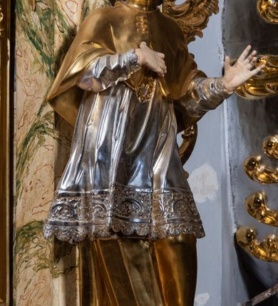 Zdjęcie nr 22: Ołtarz drewniany, prostopadłościenny z kamienną mensą, z kamiennym portatylem. Antepedium z prostokątną płyciną ujętą marmoryzowaną ramą ze złoconym karbowanym profilem. W polu przedstawienie świętej z aniołkiem podającym jej kosz kwiatów, flankowany akantową wicią akantową przeplataną z roślinną, na jasnoniebieskim tle, z datą „1754”. Nastawa ołtarzowa architektoniczna, jednoosiowa, jednokondygnacyjna ze zwieńczeniem na dwustrefowym cokole.  Retabulum flankowane parą opilastrowanych filarów, które dźwigają imposty oraz fragmenty przerwanego półkolistego przyczółka z siedzącymi puttami. Na tle filarów, na konsolach ustawione 2 figury św. Demetriusza i św. Selencjusza. Trzony pilastrów dekorowane zwisami kwiatowymi. W Polu środkowym wnęka w formie stojącego prostokąta zamkniętego łukiem segmentowym nadwieszonego z uskokiem ujęta profilowaną ramą, dekorowaną ornamentem roślinnym, z obrazem św. Heleny. Wnęka od dołu i góry flankowana ornamentem roślinnym i roccailem. Kondygnacja flankowana uszami utworzonymi z roccailu. Zwieńczenie w formie zbliżonej do trapezu o wklęsłych bokach zamknięte fragmentem gzymsu, wyłamanego na kształt łuku segmentowego nadwieszonego, z kartuszem z ornamentem roccailowym. W polu gorejące serce w otoku z obłoków i uskrzydlonych główek anielskich, w glorii promienistej.  Struktura polichromowana w sposób imitujący marmoryzację w kolorze beżowo-zielonym. Ornamentyka i profile złocone, detal i zwieńczenie srebrzone.