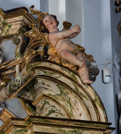 Zdjęcie nr 28: Ołtarz drewniany, prostopadłościenny z kamienną mensą, z kamiennym portatylem. Antepedium z prostokątną płyciną ujętą marmoryzowaną ramą ze złoconym karbowanym profilem. W polu przedstawienie świętej z aniołkiem podającym jej kosz kwiatów, flankowany akantową wicią akantową przeplataną z roślinną, na jasnoniebieskim tle, z datą „1754”. Nastawa ołtarzowa architektoniczna, jednoosiowa, jednokondygnacyjna ze zwieńczeniem na dwustrefowym cokole.  Retabulum flankowane parą opilastrowanych filarów, które dźwigają imposty oraz fragmenty przerwanego półkolistego przyczółka z siedzącymi puttami. Na tle filarów, na konsolach ustawione 2 figury św. Demetriusza i św. Selencjusza. Trzony pilastrów dekorowane zwisami kwiatowymi. W Polu środkowym wnęka w formie stojącego prostokąta zamkniętego łukiem segmentowym nadwieszonego z uskokiem ujęta profilowaną ramą, dekorowaną ornamentem roślinnym, z obrazem św. Heleny. Wnęka od dołu i góry flankowana ornamentem roślinnym i roccailem. Kondygnacja flankowana uszami utworzonymi z roccailu. Zwieńczenie w formie zbliżonej do trapezu o wklęsłych bokach zamknięte fragmentem gzymsu, wyłamanego na kształt łuku segmentowego nadwieszonego, z kartuszem z ornamentem roccailowym. W polu gorejące serce w otoku z obłoków i uskrzydlonych główek anielskich, w glorii promienistej.  Struktura polichromowana w sposób imitujący marmoryzację w kolorze beżowo-zielonym. Ornamentyka i profile złocone, detal i zwieńczenie srebrzone.