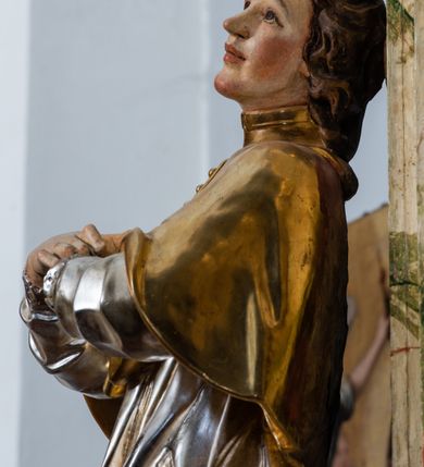 Zdjęcie nr 25: Ołtarz drewniany, prostopadłościenny z kamienną mensą, z kamiennym portatylem. Antepedium z prostokątną płyciną ujętą marmoryzowaną ramą ze złoconym karbowanym profilem. W polu przedstawienie świętej z aniołkiem podającym jej kosz kwiatów, flankowany akantową wicią akantową przeplataną z roślinną, na jasnoniebieskim tle, z datą „1754”. Nastawa ołtarzowa architektoniczna, jednoosiowa, jednokondygnacyjna ze zwieńczeniem na dwustrefowym cokole.  Retabulum flankowane parą opilastrowanych filarów, które dźwigają imposty oraz fragmenty przerwanego półkolistego przyczółka z siedzącymi puttami. Na tle filarów, na konsolach ustawione 2 figury św. Demetriusza i św. Selencjusza. Trzony pilastrów dekorowane zwisami kwiatowymi. W Polu środkowym wnęka w formie stojącego prostokąta zamkniętego łukiem segmentowym nadwieszonego z uskokiem ujęta profilowaną ramą, dekorowaną ornamentem roślinnym, z obrazem św. Heleny. Wnęka od dołu i góry flankowana ornamentem roślinnym i roccailem. Kondygnacja flankowana uszami utworzonymi z roccailu. Zwieńczenie w formie zbliżonej do trapezu o wklęsłych bokach zamknięte fragmentem gzymsu, wyłamanego na kształt łuku segmentowego nadwieszonego, z kartuszem z ornamentem roccailowym. W polu gorejące serce w otoku z obłoków i uskrzydlonych główek anielskich, w glorii promienistej.  Struktura polichromowana w sposób imitujący marmoryzację w kolorze beżowo-zielonym. Ornamentyka i profile złocone, detal i zwieńczenie srebrzone.