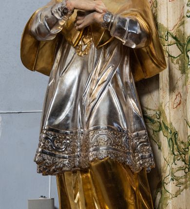 Zdjęcie nr 27: Ołtarz drewniany, prostopadłościenny z kamienną mensą, z kamiennym portatylem. Antepedium z prostokątną płyciną ujętą marmoryzowaną ramą ze złoconym karbowanym profilem. W polu przedstawienie świętej z aniołkiem podającym jej kosz kwiatów, flankowany akantową wicią akantową przeplataną z roślinną, na jasnoniebieskim tle, z datą „1754”. Nastawa ołtarzowa architektoniczna, jednoosiowa, jednokondygnacyjna ze zwieńczeniem na dwustrefowym cokole.  Retabulum flankowane parą opilastrowanych filarów, które dźwigają imposty oraz fragmenty przerwanego półkolistego przyczółka z siedzącymi puttami. Na tle filarów, na konsolach ustawione 2 figury św. Demetriusza i św. Selencjusza. Trzony pilastrów dekorowane zwisami kwiatowymi. W Polu środkowym wnęka w formie stojącego prostokąta zamkniętego łukiem segmentowym nadwieszonego z uskokiem ujęta profilowaną ramą, dekorowaną ornamentem roślinnym, z obrazem św. Heleny. Wnęka od dołu i góry flankowana ornamentem roślinnym i roccailem. Kondygnacja flankowana uszami utworzonymi z roccailu. Zwieńczenie w formie zbliżonej do trapezu o wklęsłych bokach zamknięte fragmentem gzymsu, wyłamanego na kształt łuku segmentowego nadwieszonego, z kartuszem z ornamentem roccailowym. W polu gorejące serce w otoku z obłoków i uskrzydlonych główek anielskich, w glorii promienistej.  Struktura polichromowana w sposób imitujący marmoryzację w kolorze beżowo-zielonym. Ornamentyka i profile złocone, detal i zwieńczenie srebrzone.