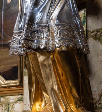 Zdjęcie nr 32: Ołtarz drewniany, prostopadłościenny z kamienną mensą, z kamiennym portatylem. Antepedium z prostokątną płyciną ujętą marmoryzowaną ramą ze złoconym karbowanym profilem. W polu przedstawienie świętej z aniołkiem podającym jej kosz kwiatów, flankowany akantową wicią akantową przeplataną z roślinną, na jasnoniebieskim tle, z datą „1754”. Nastawa ołtarzowa architektoniczna, jednoosiowa, jednokondygnacyjna ze zwieńczeniem na dwustrefowym cokole.  Retabulum flankowane parą opilastrowanych filarów, które dźwigają imposty oraz fragmenty przerwanego półkolistego przyczółka z siedzącymi puttami. Na tle filarów, na konsolach ustawione 2 figury św. Demetriusza i św. Selencjusza. Trzony pilastrów dekorowane zwisami kwiatowymi. W Polu środkowym wnęka w formie stojącego prostokąta zamkniętego łukiem segmentowym nadwieszonego z uskokiem ujęta profilowaną ramą, dekorowaną ornamentem roślinnym, z obrazem św. Heleny. Wnęka od dołu i góry flankowana ornamentem roślinnym i roccailem. Kondygnacja flankowana uszami utworzonymi z roccailu. Zwieńczenie w formie zbliżonej do trapezu o wklęsłych bokach zamknięte fragmentem gzymsu, wyłamanego na kształt łuku segmentowego nadwieszonego, z kartuszem z ornamentem roccailowym. W polu gorejące serce w otoku z obłoków i uskrzydlonych główek anielskich, w glorii promienistej.  Struktura polichromowana w sposób imitujący marmoryzację w kolorze beżowo-zielonym. Ornamentyka i profile złocone, detal i zwieńczenie srebrzone.