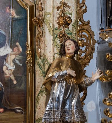 Zdjęcie nr 36: Ołtarz drewniany, prostopadłościenny z kamienną mensą, z kamiennym portatylem. Antepedium z prostokątną płyciną ujętą marmoryzowaną ramą ze złoconym karbowanym profilem. W polu przedstawienie świętej z aniołkiem podającym jej kosz kwiatów, flankowany akantową wicią akantową przeplataną z roślinną, na jasnoniebieskim tle, z datą „1754”. Nastawa ołtarzowa architektoniczna, jednoosiowa, jednokondygnacyjna ze zwieńczeniem na dwustrefowym cokole.  Retabulum flankowane parą opilastrowanych filarów, które dźwigają imposty oraz fragmenty przerwanego półkolistego przyczółka z siedzącymi puttami. Na tle filarów, na konsolach ustawione 2 figury św. Demetriusza i św. Selencjusza. Trzony pilastrów dekorowane zwisami kwiatowymi. W Polu środkowym wnęka w formie stojącego prostokąta zamkniętego łukiem segmentowym nadwieszonego z uskokiem ujęta profilowaną ramą, dekorowaną ornamentem roślinnym, z obrazem św. Heleny. Wnęka od dołu i góry flankowana ornamentem roślinnym i roccailem. Kondygnacja flankowana uszami utworzonymi z roccailu. Zwieńczenie w formie zbliżonej do trapezu o wklęsłych bokach zamknięte fragmentem gzymsu, wyłamanego na kształt łuku segmentowego nadwieszonego, z kartuszem z ornamentem roccailowym. W polu gorejące serce w otoku z obłoków i uskrzydlonych główek anielskich, w glorii promienistej.  Struktura polichromowana w sposób imitujący marmoryzację w kolorze beżowo-zielonym. Ornamentyka i profile złocone, detal i zwieńczenie srebrzone.