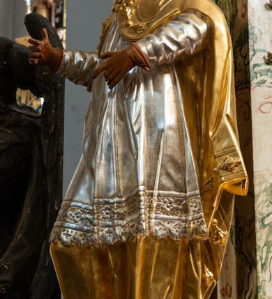 Zdjęcie nr 29: Ołtarz drewniany, prostopadłościenny z kamienną mensą, z kamiennym portatylem. Antependium z prostokątną płyciną ujętą marmoryzowaną ramą ze złoconym karbowanym profilem. W polu medalion w formie stojącego owalu z przedstawieniem zakonnika z dzieciątkiem, flankowany akantową wicią akantową przeplataną z roślinną, na jasnoniebieskim tle. Nastawa ołtarzowa architektoniczna, jednoosiowa, jednokondygnacyjna ze zwieńczeniem na dwustrefowym cokole.  Retabulum flankowane parą opilastrowanych filarów, które dźwigają imposty oraz fragmenty przerwanego półkolistego przyczółka z siedzącymi puttami. Na tle filarów, na konsolach ustawione 2 figury papieża i biskupa. Trzony pilastrów dekorowane zwisami kwiatowymi. W Polu środkowym wnęka w formie stojącego prostokąta zamkniętego łukiem segmentowym nadwieszonego z uskokiem ujęta profilowaną ramą, dekorowaną ornamentem roślinnym, z obrazem świętego Marka. Wnęka od dołu i góry flankowana ornamentem roślinnym i roccailem. Kondygnacja flankowana uszami utworzonymi z roccailu. Zwieńczenie w formie zbliżonej do trapezu o wklęsłych bokach zamknięte fragmentem gzymsu, wyłamanego na kształt łuku segmentowego nadwieszonego, z kartuszem z ornamentem roccailowym. W polu gorejące serce w otoku z obłoków i uskrzydlonych główek anielskich, w glorii promienistej.  Struktura polichromowana w sposób imitujący marmoryzację w kolorze beżowo-zielonym. Ornamentyka i profile złocone, detal i zwieńczenie srebrzone.