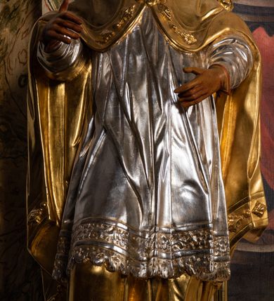 Zdjęcie nr 31: Ołtarz drewniany, prostopadłościenny z kamienną mensą, z kamiennym portatylem. Antependium z prostokątną płyciną ujętą marmoryzowaną ramą ze złoconym karbowanym profilem. W polu medalion w formie stojącego owalu z przedstawieniem zakonnika z dzieciątkiem, flankowany akantową wicią akantową przeplataną z roślinną, na jasnoniebieskim tle. Nastawa ołtarzowa architektoniczna, jednoosiowa, jednokondygnacyjna ze zwieńczeniem na dwustrefowym cokole.  Retabulum flankowane parą opilastrowanych filarów, które dźwigają imposty oraz fragmenty przerwanego półkolistego przyczółka z siedzącymi puttami. Na tle filarów, na konsolach ustawione 2 figury papieża i biskupa. Trzony pilastrów dekorowane zwisami kwiatowymi. W Polu środkowym wnęka w formie stojącego prostokąta zamkniętego łukiem segmentowym nadwieszonego z uskokiem ujęta profilowaną ramą, dekorowaną ornamentem roślinnym, z obrazem świętego Marka. Wnęka od dołu i góry flankowana ornamentem roślinnym i roccailem. Kondygnacja flankowana uszami utworzonymi z roccailu. Zwieńczenie w formie zbliżonej do trapezu o wklęsłych bokach zamknięte fragmentem gzymsu, wyłamanego na kształt łuku segmentowego nadwieszonego, z kartuszem z ornamentem roccailowym. W polu gorejące serce w otoku z obłoków i uskrzydlonych główek anielskich, w glorii promienistej.  Struktura polichromowana w sposób imitujący marmoryzację w kolorze beżowo-zielonym. Ornamentyka i profile złocone, detal i zwieńczenie srebrzone.