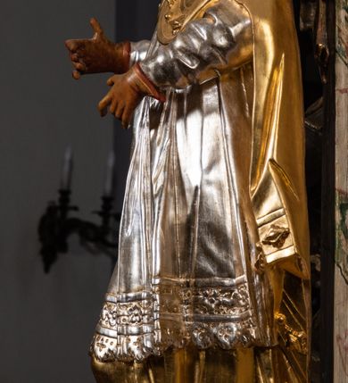 Zdjęcie nr 25: Ołtarz drewniany, prostopadłościenny z kamienną mensą, z kamiennym portatylem. Antependium z prostokątną płyciną ujętą marmoryzowaną ramą ze złoconym karbowanym profilem. W polu medalion w formie stojącego owalu z przedstawieniem zakonnika z dzieciątkiem, flankowany akantową wicią akantową przeplataną z roślinną, na jasnoniebieskim tle. Nastawa ołtarzowa architektoniczna, jednoosiowa, jednokondygnacyjna ze zwieńczeniem na dwustrefowym cokole.  Retabulum flankowane parą opilastrowanych filarów, które dźwigają imposty oraz fragmenty przerwanego półkolistego przyczółka z siedzącymi puttami. Na tle filarów, na konsolach ustawione 2 figury papieża i biskupa. Trzony pilastrów dekorowane zwisami kwiatowymi. W Polu środkowym wnęka w formie stojącego prostokąta zamkniętego łukiem segmentowym nadwieszonego z uskokiem ujęta profilowaną ramą, dekorowaną ornamentem roślinnym, z obrazem świętego Marka. Wnęka od dołu i góry flankowana ornamentem roślinnym i roccailem. Kondygnacja flankowana uszami utworzonymi z roccailu. Zwieńczenie w formie zbliżonej do trapezu o wklęsłych bokach zamknięte fragmentem gzymsu, wyłamanego na kształt łuku segmentowego nadwieszonego, z kartuszem z ornamentem roccailowym. W polu gorejące serce w otoku z obłoków i uskrzydlonych główek anielskich, w glorii promienistej.  Struktura polichromowana w sposób imitujący marmoryzację w kolorze beżowo-zielonym. Ornamentyka i profile złocone, detal i zwieńczenie srebrzone.