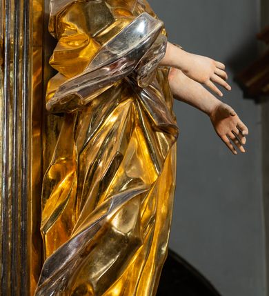 Zdjęcie nr 63: Ołtarz drewniany, prostopadłościenny z kamienną mensą, z kamiennym portatylem. Antepedium drewniane podzielone na trzy płyciny za pomocą pilastrów: w środkowej krzyż, kotwica i gorejące serce, w bocznych gorejące serce w koronie cierniowej i wieńcu z róż. Nastawa ołtarzowa architektoniczna, jednoosiowa, jednokondygnacyjna ze zwieńczeniem na cokole.  Retabulum flankowane parą zdwojonych pilastrów zakończonych konsolami,  które dźwigają pełne belkowanie oraz fragmenty przerwanego półkolistego przyczółka z siedzącymi puttami. Na tle pilastrów, na konsolach ustawione 2 figury: św. Katarzyny oraz Barbary. Trzony pilastrów dekorowane kampanulami. W Polu środkowym wnęka w formie stojącego prostokąta zamkniętego łukiem segmentowym nadwieszonego z uskokiem ujęta profilowaną ramą, z obrazem świętej Zofii z córkami, w osobnej ramie. Nad wnęką baldachim dekorowany lambrekinem, z podwieszoną tkaniną po dwóch stronach, lamowaną frędzlą. Nam baldachimem kartusz z uskrzydlonymi główkami anielskimi i zwieńczony koroną. Zwieńczenie w formie zbliżonej do trapezu o wklęsłych bokach zamknięte falistym gzymsem, dekorowanym uskrzydloną główką anielską, ujętą wolutami na tle muszli, z podwieszonymi kampanulami. W polu gołębica w otoku z obłoków i uskrzydlonych główek anielskich, w glorii promienistej.  Struktura polichromowana w sposób imitujący marmoryzację w kolorze beżowo-zielonym. Ornamentyka i profile złocone, detal i zwieńczenie srebrzone.