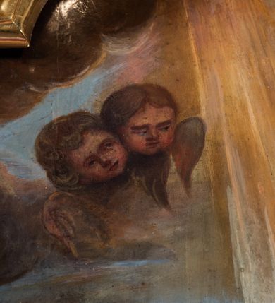 Zdjęcie nr 19: Ołtarz drewniany, prostopadłościenny z kamienną mensą, z kamiennym portatylem. Antepedium drewniane podzielone na trzy płyciny za pomocą pilastrów: w środkowej krzyż, kotwica i gorejące serce, w bocznych gorejące serce w koronie cierniowej i wieńcu z róż. Nastawa ołtarzowa architektoniczna, jednoosiowa, jednokondygnacyjna ze zwieńczeniem na cokole.  Retabulum flankowane parą zdwojonych pilastrów zakończonych konsolami,  które dźwigają pełne belkowanie oraz fragmenty przerwanego półkolistego przyczółka z siedzącymi puttami. Na tle pilastrów, na konsolach ustawione 2 figury: św. Katarzyny oraz Barbary. Trzony pilastrów dekorowane kampanulami. W Polu środkowym wnęka w formie stojącego prostokąta zamkniętego łukiem segmentowym nadwieszonego z uskokiem ujęta profilowaną ramą, z obrazem świętej Zofii z córkami, w osobnej ramie. Nad wnęką baldachim dekorowany lambrekinem, z podwieszoną tkaniną po dwóch stronach, lamowaną frędzlą. Nam baldachimem kartusz z uskrzydlonymi główkami anielskimi i zwieńczony koroną. Zwieńczenie w formie zbliżonej do trapezu o wklęsłych bokach zamknięte falistym gzymsem, dekorowanym uskrzydloną główką anielską, ujętą wolutami na tle muszli, z podwieszonymi kampanulami. W polu gołębica w otoku z obłoków i uskrzydlonych główek anielskich, w glorii promienistej.  Struktura polichromowana w sposób imitujący marmoryzację w kolorze beżowo-zielonym. Ornamentyka i profile złocone, detal i zwieńczenie srebrzone.