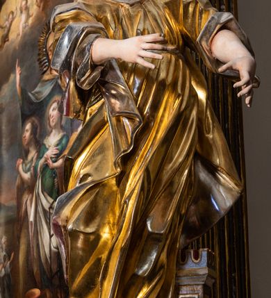 Zdjęcie nr 11: Ołtarz drewniany, prostopadłościenny z kamienną mensą, z kamiennym portatylem. Antepedium drewniane podzielone na trzy płyciny za pomocą pilastrów: w środkowej krzyż, kotwica i gorejące serce, w bocznych gorejące serce w koronie cierniowej i wieńcu z róż. Nastawa ołtarzowa architektoniczna, jednoosiowa, jednokondygnacyjna ze zwieńczeniem na cokole.  Retabulum flankowane parą zdwojonych pilastrów zakończonych konsolami,  które dźwigają pełne belkowanie oraz fragmenty przerwanego półkolistego przyczółka z siedzącymi puttami. Na tle pilastrów, na konsolach ustawione 2 figury: św. Katarzyny oraz Barbary. Trzony pilastrów dekorowane kampanulami. W Polu środkowym wnęka w formie stojącego prostokąta zamkniętego łukiem segmentowym nadwieszonego z uskokiem ujęta profilowaną ramą, z obrazem świętej Zofii z córkami, w osobnej ramie. Nad wnęką baldachim dekorowany lambrekinem, z podwieszoną tkaniną po dwóch stronach, lamowaną frędzlą. Nam baldachimem kartusz z uskrzydlonymi główkami anielskimi i zwieńczony koroną. Zwieńczenie w formie zbliżonej do trapezu o wklęsłych bokach zamknięte falistym gzymsem, dekorowanym uskrzydloną główką anielską, ujętą wolutami na tle muszli, z podwieszonymi kampanulami. W polu gołębica w otoku z obłoków i uskrzydlonych główek anielskich, w glorii promienistej.  Struktura polichromowana w sposób imitujący marmoryzację w kolorze beżowo-zielonym. Ornamentyka i profile złocone, detal i zwieńczenie srebrzone.