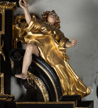 Zdjęcie nr 5: Ołtarz architektoniczny, przyścienny, jednoosiowy, jednokondygnacyjny ze zwieńczeniem, ujęty uszami z ornamentu małżowinowo-chrząstkowego. Nastawa ustawiona na wysokim cokole dekorowanym prostokątnymi płycinami ujęta kompozytowymi, złoconymi kolumnami dźwigającymi belkowanie z wydatnym gzymsem, na którym ustawione odcinki wolutowego przyczółka z siedzącymi na nich postaciami aniołów. W polu ołtarza obraz w kształcie stojącego prostokąta zamkniętego łukiem trójlistnym ściętym przedstawiający bł. Salomeę, ujęty w złoconą ramę. W partii belkowania złocone girlandy i kartusz dekorowany ornamentem małżowinowo-chrząstkowym. W zwieńczeniu obraz „Zesłanie Ducha Świętego” w kształcie stojącego prostokąta ujęty uszatą ramą. Po bokach uszy z ornamentu małżowinowo-chrząstkowego. Całość zwieńczona trójkątnym przyczółkiem z muszlą palmetową umieszczoną na szczycie. Struktura malowana na czarno, partie ornamentów i szat aniołów złocone, a ich karnacje oddane w naturalnej kolorystyce. 