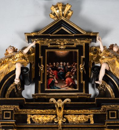 Zdjęcie nr 16: Ołtarz architektoniczny, przyścienny, jednoosiowy, jednokondygnacyjny ze zwieńczeniem, ujęty uszami z ornamentu małżowinowo-chrząstkowego. Nastawa ustawiona na wysokim cokole dekorowanym prostokątnymi płycinami ujęta kompozytowymi, złoconymi kolumnami dźwigającymi belkowanie z wydatnym gzymsem, na którym ustawione odcinki wolutowego przyczółka z siedzącymi na nich postaciami aniołów. W polu ołtarza obraz w kształcie stojącego prostokąta zamkniętego łukiem trójlistnym ściętym przedstawiający bł. Salomeę, ujęty w złoconą ramę. W partii belkowania złocone girlandy i kartusz dekorowany ornamentem małżowinowo-chrząstkowym. W zwieńczeniu obraz „Zesłanie Ducha Świętego” w kształcie stojącego prostokąta ujęty uszatą ramą. Po bokach uszy z ornamentu małżowinowo-chrząstkowego. Całość zwieńczona trójkątnym przyczółkiem z muszlą palmetową umieszczoną na szczycie. Struktura malowana na czarno, partie ornamentów i szat aniołów złocone, a ich karnacje oddane w naturalnej kolorystyce. 