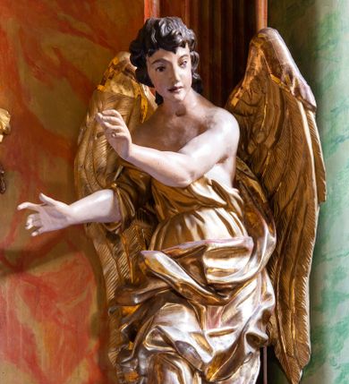 Zdjęcie nr 1: Para pełnoplastycznych figur ustawionych na niewielkich, prostopadłościennych postumentach. Postaci przedstawione w pozycji stojącej, w kontrapoście. Aniołowie ukazani jako ciemnowłosi młodzieńcy o owalnych twarzach ubrani w złote szaty tworzące dynamicznie wyginające się fałdy. Torsy odsłonięte, stopy bose. Anioł z lewej strony ołtarza unosi prawą rękę do góry w geście oratorskim, lewą ugiętą w łokciu wyciąga przed siebie. Lewa noga ugięta w kolanie. Anioł z prawej strony obie ręce ugięte w łokciach wyciąga w prawo. Szaty i skrzydła złocone, karnacje aniołów polichromowane.