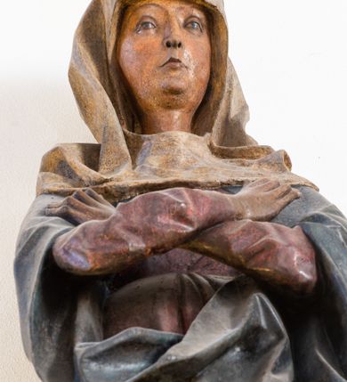 Zdjęcie nr 7: Rzeźba przedstawiająca ukrzyżowanego Chrystusa o ciele ukazanym w delikatnym zwisie ze szczupłymi, wyprężonymi ramionami tworzącymi zarys litery „V”. Głowa Zbawiciela pochylona na prawe ramię z umieszczoną na niej cierniową koroną w formie kołpaka i złoconym nimbem promienistym. Twarz Chrystusa szczupła, oczy zamknięte, nos długi prosty, usta otwarte. Długie, ciemne włosy spływają na prawe ramię długim, skręconym lokiem. Zarost krótki, ciemnobrązowy. Ciało Chrystusa z widoczną raną w prawym boku oddane realistycznie, stopy przebite jednym gwoździem. Wokół bioder udrapowane krótkie, złocone perizonium tworzące płytkie fałdy. U szczytu pionowej belki krzyża titulus w formie banderoli z napisem „INRI”. Krzyż prosty, drewniany w kolorze ciemnobrązowym. Figura w pełni polichromowana, perizonium i nimb złocone.