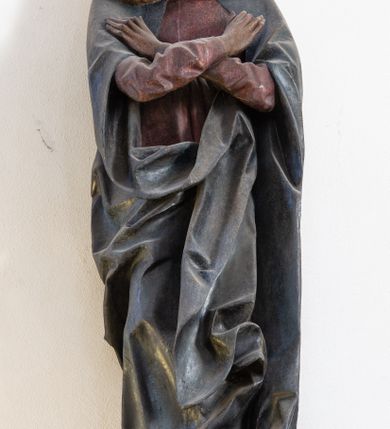Zdjęcie nr 8: Rzeźba przedstawiająca ukrzyżowanego Chrystusa o ciele ukazanym w delikatnym zwisie ze szczupłymi, wyprężonymi ramionami tworzącymi zarys litery „V”. Głowa Zbawiciela pochylona na prawe ramię z umieszczoną na niej cierniową koroną w formie kołpaka i złoconym nimbem promienistym. Twarz Chrystusa szczupła, oczy zamknięte, nos długi prosty, usta otwarte. Długie, ciemne włosy spływają na prawe ramię długim, skręconym lokiem. Zarost krótki, ciemnobrązowy. Ciało Chrystusa z widoczną raną w prawym boku oddane realistycznie, stopy przebite jednym gwoździem. Wokół bioder udrapowane krótkie, złocone perizonium tworzące płytkie fałdy. U szczytu pionowej belki krzyża titulus w formie banderoli z napisem „INRI”. Krzyż prosty, drewniany w kolorze ciemnobrązowym. Figura w pełni polichromowana, perizonium i nimb złocone.