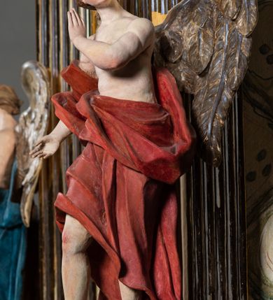 Zdjęcie nr 12: Ołtarz architektoniczny, jednoosiowy, jednokondygnacyjny, ze zwieńczeniem. Ołtarz prostopadłościeny z drewnianą, współczesną mensą i antependium z przedstawieniem Chrystusa na głazie w otoczeniu wieńca z kwiatami. Nastawa ujęta ukośnie dostawionymi filarami kanelowanymi, ustawionymi na postumentach z konsolami o prostych kapitelach utworzonych z roccailli i konsol podtrzymujących przerwane belkowanie zwieńczone ćwierćkolistymi naczółkami. Zwieńczenie o wklęsłych bokach zwieńczone profilowanym gzymsem w kształcie łuku nadwieszonego półkolistego. Na tle filaru, na konsolach ustawione figury uskrzydlonych aniołów. W polu środkowym obraz w kształcie stojącego prostokąta zamkniętego łukiem nadwieszonym półkolistym ozdobniony rocaillem. W ramie obraz z przedstawieniem Matki Boskiej Bolesnej. Nad ramą baldachim z lambrekinem zwieńczony stylizowaną roccaillową muszlą. W zwieńczeniu serce Gorejące na tle glorii promienistej z chmurkami, zwieńczonej uskrzydloną główką anielską; nad gzymsem zwieńczenia  grzebień utworzony z ażurowego rocaillu.