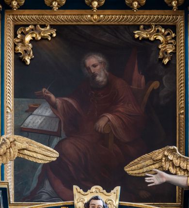 Zdjęcie nr 43: Ołtarz architektoniczny, trójosiowy, dwukondygnacyjny ze zwieńczeniem. Mensa prostopadłościenna, kamienna z drewnianym antepedium w formie leżącego prostokąta z postacią św. Augustyna ujętego wicią suchego akantu z przeplecioną, karbowaną wstążką i bukietami kwiatów. Przedstawienie otoczone profilowaną, ażurową ramą wypełnioną podobną wicią z akantu i kwiatów. Na mensie prostopadłościenne tabernakulum w formie kapliczki. Ściana frontowa z drzwiczkami w kształcie stojącego prostokąta dekorowanego krzyżem łacińskim ujętym wicią roślinną, zwieńczona trójkątnym przyczółkiem. Ścianka ujęta lizenami wypełnionymi wicią akantową podtrzymującymi pełne belkowanie obiegające bryłę, z mocno wysuniętym gzymsem wyłamanym w narożach. Całość zwieńczona czterospadowym dachem dekorowanym łuską. Na dachu baranek Boży leżący na księdze z siedmioma pieczęciami, przytrzymujący chorągiew, ukazany na tle chrystogramu otoczonego glorią promienistą. 
Nastawa na dwudzielnym cokole z półkolistymi bramkami ze zwieńczeniem utworzonym z ornamentu okuciowego ujmującego owalne pola. Osie pierwszej kondygnacji wydzielone kolumnami stojącymi na konsolach dekorowanych z frontu uskrzydlonymi główkami anielskimi powyżej liści akantu, na krawędziach cekinami, a po bokach wicią. Kolumny zostały przedzielone opaską w jednej trzeciej wysokości, dekorowane na całej wysokości wicią roślinną, główkami anielskimi w dolnej partii i imitacją kameryzacji na opaskach oraz w dwóch trzecich wysokości. Kolumny są ustawione na tle pilastrów dekorowanych wicią roślinną i zawieszonymi na niej chustkami. W polu centralnym kondygnacji jest nisza w kształcie stojącego prostokąta zamkniętego łukiem pełnym z postacią ukrzyżowanego Chrystusa na tle widoku Jerozolimy. W osiach bocznych mniejsze, ujęte pilastrami nisze o podobnym kształcie, których konchy wypełnione są muszlą, zwieńczone trójkątnym przyczółkiem przerwanym na cokół. W nich, na dekorowanych wicią i rozetami konsolach ustawiono figury: po lewej stronie św. Piotra, a po prawej św. Pawła. Kondygnacje ujmują ażurowe uszaki utworzone z ornamentu okuciowego, ulistnionych wolut i przewieszonej chustki. Kolumny podtrzymują pełne belkowanie wyniesione w łuk nad polem centralnym. Podłucze dekorowane rozetami, fryz głowami anielskimi i wicią, gzyms m.in. kostkowaniem i liśćmi akantu. Całość spięta kluczem z kartuszem z herbem kanoników regularnych od pokuty (marków). Na wyniesieniu belkowania posadowiono postaci aniołów trzymających narzędzia męki: anioł po lewej włócznię, a anioł po prawej gąbkę. Górna kondygnacja oparta została na schemacie aediculi – prostokątne pole ujęto kolumnami podtrzymującymi pełne belkowanie i trójkątny przyczółek przerwany na środku na cokół, na którym ustawiono rzeźbę  pelikana karmiącego młode własną krwią. Na krawędziach przyczółka dwie leżące postaci. Kondygnacja flankowana postaciami czterech ewangelistów ustawionymi na cokołach. Po lewej stronie św. Marek i św. Jan, po prawej św. Mateusz i św. Łukasz. Struktura polichromowana na kolor ciemnoniebieski; kolumny, profile, detale i ornamenty złocone i srebrzone.
