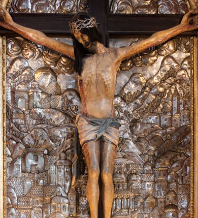 Zdjęcie nr 4: Ołtarz architektoniczny, trójosiowy, dwukondygnacyjny ze zwieńczeniem. Mensa prostopadłościenna, kamienna z drewnianym antepedium w formie leżącego prostokąta z postacią św. Augustyna ujętego wicią suchego akantu z przeplecioną, karbowaną wstążką i bukietami kwiatów. Przedstawienie otoczone profilowaną, ażurową ramą wypełnioną podobną wicią z akantu i kwiatów. Na mensie prostopadłościenne tabernakulum w formie kapliczki. Ściana frontowa z drzwiczkami w kształcie stojącego prostokąta dekorowanego krzyżem łacińskim ujętym wicią roślinną, zwieńczona trójkątnym przyczółkiem. Ścianka ujęta lizenami wypełnionymi wicią akantową podtrzymującymi pełne belkowanie obiegające bryłę, z mocno wysuniętym gzymsem wyłamanym w narożach. Całość zwieńczona czterospadowym dachem dekorowanym łuską. Na dachu baranek Boży leżący na księdze z siedmioma pieczęciami, przytrzymujący chorągiew, ukazany na tle chrystogramu otoczonego glorią promienistą. 
Nastawa na dwudzielnym cokole z półkolistymi bramkami ze zwieńczeniem utworzonym z ornamentu okuciowego ujmującego owalne pola. Osie pierwszej kondygnacji wydzielone kolumnami stojącymi na konsolach dekorowanych z frontu uskrzydlonymi główkami anielskimi powyżej liści akantu, na krawędziach cekinami, a po bokach wicią. Kolumny zostały przedzielone opaską w jednej trzeciej wysokości, dekorowane na całej wysokości wicią roślinną, główkami anielskimi w dolnej partii i imitacją kameryzacji na opaskach oraz w dwóch trzecich wysokości. Kolumny są ustawione na tle pilastrów dekorowanych wicią roślinną i zawieszonymi na niej chustkami. W polu centralnym kondygnacji jest nisza w kształcie stojącego prostokąta zamkniętego łukiem pełnym z postacią ukrzyżowanego Chrystusa na tle widoku Jerozolimy. W osiach bocznych mniejsze, ujęte pilastrami nisze o podobnym kształcie, których konchy wypełnione są muszlą, zwieńczone trójkątnym przyczółkiem przerwanym na cokół. W nich, na dekorowanych wicią i rozetami konsolach ustawiono figury: po lewej stronie św. Piotra, a po prawej św. Pawła. Kondygnacje ujmują ażurowe uszaki utworzone z ornamentu okuciowego, ulistnionych wolut i przewieszonej chustki. Kolumny podtrzymują pełne belkowanie wyniesione w łuk nad polem centralnym. Podłucze dekorowane rozetami, fryz głowami anielskimi i wicią, gzyms m.in. kostkowaniem i liśćmi akantu. Całość spięta kluczem z kartuszem z herbem kanoników regularnych od pokuty (marków). Na wyniesieniu belkowania posadowiono postaci aniołów trzymających narzędzia męki: anioł po lewej włócznię, a anioł po prawej gąbkę. Górna kondygnacja oparta została na schemacie aediculi – prostokątne pole ujęto kolumnami podtrzymującymi pełne belkowanie i trójkątny przyczółek przerwany na środku na cokół, na którym ustawiono rzeźbę  pelikana karmiącego młode własną krwią. Na krawędziach przyczółka dwie leżące postaci. Kondygnacja flankowana postaciami czterech ewangelistów ustawionymi na cokołach. Po lewej stronie św. Marek i św. Jan, po prawej św. Mateusz i św. Łukasz. Struktura polichromowana na kolor ciemnoniebieski; kolumny, profile, detale i ornamenty złocone i srebrzone.
