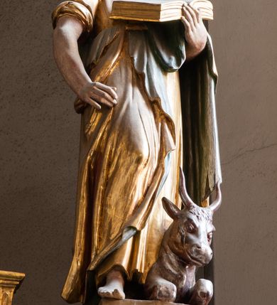 Zdjęcie nr 28: Ołtarz architektoniczny, trójosiowy, dwukondygnacyjny ze zwieńczeniem. Mensa prostopadłościenna, kamienna z drewnianym antepedium w formie leżącego prostokąta z postacią św. Augustyna ujętego wicią suchego akantu z przeplecioną, karbowaną wstążką i bukietami kwiatów. Przedstawienie otoczone profilowaną, ażurową ramą wypełnioną podobną wicią z akantu i kwiatów. Na mensie prostopadłościenne tabernakulum w formie kapliczki. Ściana frontowa z drzwiczkami w kształcie stojącego prostokąta dekorowanego krzyżem łacińskim ujętym wicią roślinną, zwieńczona trójkątnym przyczółkiem. Ścianka ujęta lizenami wypełnionymi wicią akantową podtrzymującymi pełne belkowanie obiegające bryłę, z mocno wysuniętym gzymsem wyłamanym w narożach. Całość zwieńczona czterospadowym dachem dekorowanym łuską. Na dachu baranek Boży leżący na księdze z siedmioma pieczęciami, przytrzymujący chorągiew, ukazany na tle chrystogramu otoczonego glorią promienistą. 
Nastawa na dwudzielnym cokole z półkolistymi bramkami ze zwieńczeniem utworzonym z ornamentu okuciowego ujmującego owalne pola. Osie pierwszej kondygnacji wydzielone kolumnami stojącymi na konsolach dekorowanych z frontu uskrzydlonymi główkami anielskimi powyżej liści akantu, na krawędziach cekinami, a po bokach wicią. Kolumny zostały przedzielone opaską w jednej trzeciej wysokości, dekorowane na całej wysokości wicią roślinną, główkami anielskimi w dolnej partii i imitacją kameryzacji na opaskach oraz w dwóch trzecich wysokości. Kolumny są ustawione na tle pilastrów dekorowanych wicią roślinną i zawieszonymi na niej chustkami. W polu centralnym kondygnacji jest nisza w kształcie stojącego prostokąta zamkniętego łukiem pełnym z postacią ukrzyżowanego Chrystusa na tle widoku Jerozolimy. W osiach bocznych mniejsze, ujęte pilastrami nisze o podobnym kształcie, których konchy wypełnione są muszlą, zwieńczone trójkątnym przyczółkiem przerwanym na cokół. W nich, na dekorowanych wicią i rozetami konsolach ustawiono figury: po lewej stronie św. Piotra, a po prawej św. Pawła. Kondygnacje ujmują ażurowe uszaki utworzone z ornamentu okuciowego, ulistnionych wolut i przewieszonej chustki. Kolumny podtrzymują pełne belkowanie wyniesione w łuk nad polem centralnym. Podłucze dekorowane rozetami, fryz głowami anielskimi i wicią, gzyms m.in. kostkowaniem i liśćmi akantu. Całość spięta kluczem z kartuszem z herbem kanoników regularnych od pokuty (marków). Na wyniesieniu belkowania posadowiono postaci aniołów trzymających narzędzia męki: anioł po lewej włócznię, a anioł po prawej gąbkę. Górna kondygnacja oparta została na schemacie aediculi – prostokątne pole ujęto kolumnami podtrzymującymi pełne belkowanie i trójkątny przyczółek przerwany na środku na cokół, na którym ustawiono rzeźbę  pelikana karmiącego młode własną krwią. Na krawędziach przyczółka dwie leżące postaci. Kondygnacja flankowana postaciami czterech ewangelistów ustawionymi na cokołach. Po lewej stronie św. Marek i św. Jan, po prawej św. Mateusz i św. Łukasz. Struktura polichromowana na kolor ciemnoniebieski; kolumny, profile, detale i ornamenty złocone i srebrzone.
