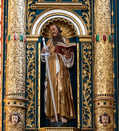 Zdjęcie nr 32: Ołtarz architektoniczny, trójosiowy, dwukondygnacyjny ze zwieńczeniem. Mensa prostopadłościenna, kamienna z drewnianym antepedium w formie leżącego prostokąta z postacią św. Augustyna ujętego wicią suchego akantu z przeplecioną, karbowaną wstążką i bukietami kwiatów. Przedstawienie otoczone profilowaną, ażurową ramą wypełnioną podobną wicią z akantu i kwiatów. Na mensie prostopadłościenne tabernakulum w formie kapliczki. Ściana frontowa z drzwiczkami w kształcie stojącego prostokąta dekorowanego krzyżem łacińskim ujętym wicią roślinną, zwieńczona trójkątnym przyczółkiem. Ścianka ujęta lizenami wypełnionymi wicią akantową podtrzymującymi pełne belkowanie obiegające bryłę, z mocno wysuniętym gzymsem wyłamanym w narożach. Całość zwieńczona czterospadowym dachem dekorowanym łuską. Na dachu baranek Boży leżący na księdze z siedmioma pieczęciami, przytrzymujący chorągiew, ukazany na tle chrystogramu otoczonego glorią promienistą. 
Nastawa na dwudzielnym cokole z półkolistymi bramkami ze zwieńczeniem utworzonym z ornamentu okuciowego ujmującego owalne pola. Osie pierwszej kondygnacji wydzielone kolumnami stojącymi na konsolach dekorowanych z frontu uskrzydlonymi główkami anielskimi powyżej liści akantu, na krawędziach cekinami, a po bokach wicią. Kolumny zostały przedzielone opaską w jednej trzeciej wysokości, dekorowane na całej wysokości wicią roślinną, główkami anielskimi w dolnej partii i imitacją kameryzacji na opaskach oraz w dwóch trzecich wysokości. Kolumny są ustawione na tle pilastrów dekorowanych wicią roślinną i zawieszonymi na niej chustkami. W polu centralnym kondygnacji jest nisza w kształcie stojącego prostokąta zamkniętego łukiem pełnym z postacią ukrzyżowanego Chrystusa na tle widoku Jerozolimy. W osiach bocznych mniejsze, ujęte pilastrami nisze o podobnym kształcie, których konchy wypełnione są muszlą, zwieńczone trójkątnym przyczółkiem przerwanym na cokół. W nich, na dekorowanych wicią i rozetami konsolach ustawiono figury: po lewej stronie św. Piotra, a po prawej św. Pawła. Kondygnacje ujmują ażurowe uszaki utworzone z ornamentu okuciowego, ulistnionych wolut i przewieszonej chustki. Kolumny podtrzymują pełne belkowanie wyniesione w łuk nad polem centralnym. Podłucze dekorowane rozetami, fryz głowami anielskimi i wicią, gzyms m.in. kostkowaniem i liśćmi akantu. Całość spięta kluczem z kartuszem z herbem kanoników regularnych od pokuty (marków). Na wyniesieniu belkowania posadowiono postaci aniołów trzymających narzędzia męki: anioł po lewej włócznię, a anioł po prawej gąbkę. Górna kondygnacja oparta została na schemacie aediculi – prostokątne pole ujęto kolumnami podtrzymującymi pełne belkowanie i trójkątny przyczółek przerwany na środku na cokół, na którym ustawiono rzeźbę  pelikana karmiącego młode własną krwią. Na krawędziach przyczółka dwie leżące postaci. Kondygnacja flankowana postaciami czterech ewangelistów ustawionymi na cokołach. Po lewej stronie św. Marek i św. Jan, po prawej św. Mateusz i św. Łukasz. Struktura polichromowana na kolor ciemnoniebieski; kolumny, profile, detale i ornamenty złocone i srebrzone.
