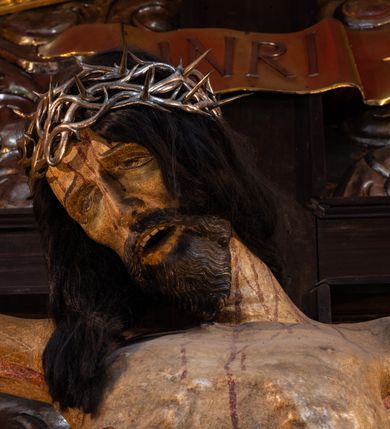 Zdjęcie nr 11: Ołtarz architektoniczny, trójosiowy, dwukondygnacyjny ze zwieńczeniem. Mensa prostopadłościenna, kamienna z drewnianym antepedium w formie leżącego prostokąta z postacią św. Augustyna ujętego wicią suchego akantu z przeplecioną, karbowaną wstążką i bukietami kwiatów. Przedstawienie otoczone profilowaną, ażurową ramą wypełnioną podobną wicią z akantu i kwiatów. Na mensie prostopadłościenne tabernakulum w formie kapliczki. Ściana frontowa z drzwiczkami w kształcie stojącego prostokąta dekorowanego krzyżem łacińskim ujętym wicią roślinną, zwieńczona trójkątnym przyczółkiem. Ścianka ujęta lizenami wypełnionymi wicią akantową podtrzymującymi pełne belkowanie obiegające bryłę, z mocno wysuniętym gzymsem wyłamanym w narożach. Całość zwieńczona czterospadowym dachem dekorowanym łuską. Na dachu baranek Boży leżący na księdze z siedmioma pieczęciami, przytrzymujący chorągiew, ukazany na tle chrystogramu otoczonego glorią promienistą. 
Nastawa na dwudzielnym cokole z półkolistymi bramkami ze zwieńczeniem utworzonym z ornamentu okuciowego ujmującego owalne pola. Osie pierwszej kondygnacji wydzielone kolumnami stojącymi na konsolach dekorowanych z frontu uskrzydlonymi główkami anielskimi powyżej liści akantu, na krawędziach cekinami, a po bokach wicią. Kolumny zostały przedzielone opaską w jednej trzeciej wysokości, dekorowane na całej wysokości wicią roślinną, główkami anielskimi w dolnej partii i imitacją kameryzacji na opaskach oraz w dwóch trzecich wysokości. Kolumny są ustawione na tle pilastrów dekorowanych wicią roślinną i zawieszonymi na niej chustkami. W polu centralnym kondygnacji jest nisza w kształcie stojącego prostokąta zamkniętego łukiem pełnym z postacią ukrzyżowanego Chrystusa na tle widoku Jerozolimy. W osiach bocznych mniejsze, ujęte pilastrami nisze o podobnym kształcie, których konchy wypełnione są muszlą, zwieńczone trójkątnym przyczółkiem przerwanym na cokół. W nich, na dekorowanych wicią i rozetami konsolach ustawiono figury: po lewej stronie św. Piotra, a po prawej św. Pawła. Kondygnacje ujmują ażurowe uszaki utworzone z ornamentu okuciowego, ulistnionych wolut i przewieszonej chustki. Kolumny podtrzymują pełne belkowanie wyniesione w łuk nad polem centralnym. Podłucze dekorowane rozetami, fryz głowami anielskimi i wicią, gzyms m.in. kostkowaniem i liśćmi akantu. Całość spięta kluczem z kartuszem z herbem kanoników regularnych od pokuty (marków). Na wyniesieniu belkowania posadowiono postaci aniołów trzymających narzędzia męki: anioł po lewej włócznię, a anioł po prawej gąbkę. Górna kondygnacja oparta została na schemacie aediculi – prostokątne pole ujęto kolumnami podtrzymującymi pełne belkowanie i trójkątny przyczółek przerwany na środku na cokół, na którym ustawiono rzeźbę  pelikana karmiącego młode własną krwią. Na krawędziach przyczółka dwie leżące postaci. Kondygnacja flankowana postaciami czterech ewangelistów ustawionymi na cokołach. Po lewej stronie św. Marek i św. Jan, po prawej św. Mateusz i św. Łukasz. Struktura polichromowana na kolor ciemnoniebieski; kolumny, profile, detale i ornamenty złocone i srebrzone.
