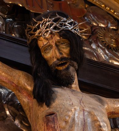 Zdjęcie nr 10: Ołtarz architektoniczny, trójosiowy, dwukondygnacyjny ze zwieńczeniem. Mensa prostopadłościenna, kamienna z drewnianym antepedium w formie leżącego prostokąta z postacią św. Augustyna ujętego wicią suchego akantu z przeplecioną, karbowaną wstążką i bukietami kwiatów. Przedstawienie otoczone profilowaną, ażurową ramą wypełnioną podobną wicią z akantu i kwiatów. Na mensie prostopadłościenne tabernakulum w formie kapliczki. Ściana frontowa z drzwiczkami w kształcie stojącego prostokąta dekorowanego krzyżem łacińskim ujętym wicią roślinną, zwieńczona trójkątnym przyczółkiem. Ścianka ujęta lizenami wypełnionymi wicią akantową podtrzymującymi pełne belkowanie obiegające bryłę, z mocno wysuniętym gzymsem wyłamanym w narożach. Całość zwieńczona czterospadowym dachem dekorowanym łuską. Na dachu baranek Boży leżący na księdze z siedmioma pieczęciami, przytrzymujący chorągiew, ukazany na tle chrystogramu otoczonego glorią promienistą. 
Nastawa na dwudzielnym cokole z półkolistymi bramkami ze zwieńczeniem utworzonym z ornamentu okuciowego ujmującego owalne pola. Osie pierwszej kondygnacji wydzielone kolumnami stojącymi na konsolach dekorowanych z frontu uskrzydlonymi główkami anielskimi powyżej liści akantu, na krawędziach cekinami, a po bokach wicią. Kolumny zostały przedzielone opaską w jednej trzeciej wysokości, dekorowane na całej wysokości wicią roślinną, główkami anielskimi w dolnej partii i imitacją kameryzacji na opaskach oraz w dwóch trzecich wysokości. Kolumny są ustawione na tle pilastrów dekorowanych wicią roślinną i zawieszonymi na niej chustkami. W polu centralnym kondygnacji jest nisza w kształcie stojącego prostokąta zamkniętego łukiem pełnym z postacią ukrzyżowanego Chrystusa na tle widoku Jerozolimy. W osiach bocznych mniejsze, ujęte pilastrami nisze o podobnym kształcie, których konchy wypełnione są muszlą, zwieńczone trójkątnym przyczółkiem przerwanym na cokół. W nich, na dekorowanych wicią i rozetami konsolach ustawiono figury: po lewej stronie św. Piotra, a po prawej św. Pawła. Kondygnacje ujmują ażurowe uszaki utworzone z ornamentu okuciowego, ulistnionych wolut i przewieszonej chustki. Kolumny podtrzymują pełne belkowanie wyniesione w łuk nad polem centralnym. Podłucze dekorowane rozetami, fryz głowami anielskimi i wicią, gzyms m.in. kostkowaniem i liśćmi akantu. Całość spięta kluczem z kartuszem z herbem kanoników regularnych od pokuty (marków). Na wyniesieniu belkowania posadowiono postaci aniołów trzymających narzędzia męki: anioł po lewej włócznię, a anioł po prawej gąbkę. Górna kondygnacja oparta została na schemacie aediculi – prostokątne pole ujęto kolumnami podtrzymującymi pełne belkowanie i trójkątny przyczółek przerwany na środku na cokół, na którym ustawiono rzeźbę  pelikana karmiącego młode własną krwią. Na krawędziach przyczółka dwie leżące postaci. Kondygnacja flankowana postaciami czterech ewangelistów ustawionymi na cokołach. Po lewej stronie św. Marek i św. Jan, po prawej św. Mateusz i św. Łukasz. Struktura polichromowana na kolor ciemnoniebieski; kolumny, profile, detale i ornamenty złocone i srebrzone.
