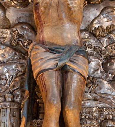 Zdjęcie nr 13: Ołtarz architektoniczny, trójosiowy, dwukondygnacyjny ze zwieńczeniem. Mensa prostopadłościenna, kamienna z drewnianym antepedium w formie leżącego prostokąta z postacią św. Augustyna ujętego wicią suchego akantu z przeplecioną, karbowaną wstążką i bukietami kwiatów. Przedstawienie otoczone profilowaną, ażurową ramą wypełnioną podobną wicią z akantu i kwiatów. Na mensie prostopadłościenne tabernakulum w formie kapliczki. Ściana frontowa z drzwiczkami w kształcie stojącego prostokąta dekorowanego krzyżem łacińskim ujętym wicią roślinną, zwieńczona trójkątnym przyczółkiem. Ścianka ujęta lizenami wypełnionymi wicią akantową podtrzymującymi pełne belkowanie obiegające bryłę, z mocno wysuniętym gzymsem wyłamanym w narożach. Całość zwieńczona czterospadowym dachem dekorowanym łuską. Na dachu baranek Boży leżący na księdze z siedmioma pieczęciami, przytrzymujący chorągiew, ukazany na tle chrystogramu otoczonego glorią promienistą. 
Nastawa na dwudzielnym cokole z półkolistymi bramkami ze zwieńczeniem utworzonym z ornamentu okuciowego ujmującego owalne pola. Osie pierwszej kondygnacji wydzielone kolumnami stojącymi na konsolach dekorowanych z frontu uskrzydlonymi główkami anielskimi powyżej liści akantu, na krawędziach cekinami, a po bokach wicią. Kolumny zostały przedzielone opaską w jednej trzeciej wysokości, dekorowane na całej wysokości wicią roślinną, główkami anielskimi w dolnej partii i imitacją kameryzacji na opaskach oraz w dwóch trzecich wysokości. Kolumny są ustawione na tle pilastrów dekorowanych wicią roślinną i zawieszonymi na niej chustkami. W polu centralnym kondygnacji jest nisza w kształcie stojącego prostokąta zamkniętego łukiem pełnym z postacią ukrzyżowanego Chrystusa na tle widoku Jerozolimy. W osiach bocznych mniejsze, ujęte pilastrami nisze o podobnym kształcie, których konchy wypełnione są muszlą, zwieńczone trójkątnym przyczółkiem przerwanym na cokół. W nich, na dekorowanych wicią i rozetami konsolach ustawiono figury: po lewej stronie św. Piotra, a po prawej św. Pawła. Kondygnacje ujmują ażurowe uszaki utworzone z ornamentu okuciowego, ulistnionych wolut i przewieszonej chustki. Kolumny podtrzymują pełne belkowanie wyniesione w łuk nad polem centralnym. Podłucze dekorowane rozetami, fryz głowami anielskimi i wicią, gzyms m.in. kostkowaniem i liśćmi akantu. Całość spięta kluczem z kartuszem z herbem kanoników regularnych od pokuty (marków). Na wyniesieniu belkowania posadowiono postaci aniołów trzymających narzędzia męki: anioł po lewej włócznię, a anioł po prawej gąbkę. Górna kondygnacja oparta została na schemacie aediculi – prostokątne pole ujęto kolumnami podtrzymującymi pełne belkowanie i trójkątny przyczółek przerwany na środku na cokół, na którym ustawiono rzeźbę  pelikana karmiącego młode własną krwią. Na krawędziach przyczółka dwie leżące postaci. Kondygnacja flankowana postaciami czterech ewangelistów ustawionymi na cokołach. Po lewej stronie św. Marek i św. Jan, po prawej św. Mateusz i św. Łukasz. Struktura polichromowana na kolor ciemnoniebieski; kolumny, profile, detale i ornamenty złocone i srebrzone.
