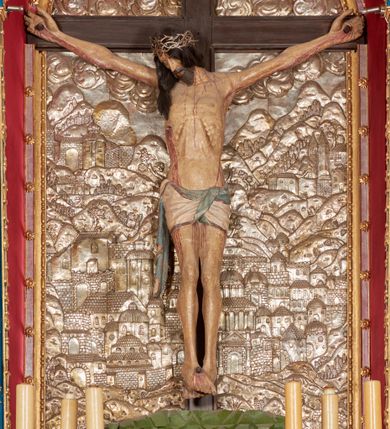 Zdjęcie nr 44: Ołtarz architektoniczny, trójosiowy, dwukondygnacyjny ze zwieńczeniem. Mensa prostopadłościenna, kamienna z drewnianym antepedium w formie leżącego prostokąta z postacią św. Augustyna ujętego wicią suchego akantu z przeplecioną, karbowaną wstążką i bukietami kwiatów. Przedstawienie otoczone profilowaną, ażurową ramą wypełnioną podobną wicią z akantu i kwiatów. Na mensie prostopadłościenne tabernakulum w formie kapliczki. Ściana frontowa z drzwiczkami w kształcie stojącego prostokąta dekorowanego krzyżem łacińskim ujętym wicią roślinną, zwieńczona trójkątnym przyczółkiem. Ścianka ujęta lizenami wypełnionymi wicią akantową podtrzymującymi pełne belkowanie obiegające bryłę, z mocno wysuniętym gzymsem wyłamanym w narożach. Całość zwieńczona czterospadowym dachem dekorowanym łuską. Na dachu baranek Boży leżący na księdze z siedmioma pieczęciami, przytrzymujący chorągiew, ukazany na tle chrystogramu otoczonego glorią promienistą. 
Nastawa na dwudzielnym cokole z półkolistymi bramkami ze zwieńczeniem utworzonym z ornamentu okuciowego ujmującego owalne pola. Osie pierwszej kondygnacji wydzielone kolumnami stojącymi na konsolach dekorowanych z frontu uskrzydlonymi główkami anielskimi powyżej liści akantu, na krawędziach cekinami, a po bokach wicią. Kolumny zostały przedzielone opaską w jednej trzeciej wysokości, dekorowane na całej wysokości wicią roślinną, główkami anielskimi w dolnej partii i imitacją kameryzacji na opaskach oraz w dwóch trzecich wysokości. Kolumny są ustawione na tle pilastrów dekorowanych wicią roślinną i zawieszonymi na niej chustkami. W polu centralnym kondygnacji jest nisza w kształcie stojącego prostokąta zamkniętego łukiem pełnym z postacią ukrzyżowanego Chrystusa na tle widoku Jerozolimy. W osiach bocznych mniejsze, ujęte pilastrami nisze o podobnym kształcie, których konchy wypełnione są muszlą, zwieńczone trójkątnym przyczółkiem przerwanym na cokół. W nich, na dekorowanych wicią i rozetami konsolach ustawiono figury: po lewej stronie św. Piotra, a po prawej św. Pawła. Kondygnacje ujmują ażurowe uszaki utworzone z ornamentu okuciowego, ulistnionych wolut i przewieszonej chustki. Kolumny podtrzymują pełne belkowanie wyniesione w łuk nad polem centralnym. Podłucze dekorowane rozetami, fryz głowami anielskimi i wicią, gzyms m.in. kostkowaniem i liśćmi akantu. Całość spięta kluczem z kartuszem z herbem kanoników regularnych od pokuty (marków). Na wyniesieniu belkowania posadowiono postaci aniołów trzymających narzędzia męki: anioł po lewej włócznię, a anioł po prawej gąbkę. Górna kondygnacja oparta została na schemacie aediculi – prostokątne pole ujęto kolumnami podtrzymującymi pełne belkowanie i trójkątny przyczółek przerwany na środku na cokół, na którym ustawiono rzeźbę  pelikana karmiącego młode własną krwią. Na krawędziach przyczółka dwie leżące postaci. Kondygnacja flankowana postaciami czterech ewangelistów ustawionymi na cokołach. Po lewej stronie św. Marek i św. Jan, po prawej św. Mateusz i św. Łukasz. Struktura polichromowana na kolor ciemnoniebieski; kolumny, profile, detale i ornamenty złocone i srebrzone.
