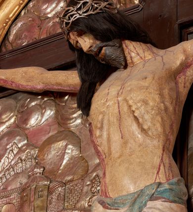 Zdjęcie nr 47: Ołtarz architektoniczny, trójosiowy, dwukondygnacyjny ze zwieńczeniem. Mensa prostopadłościenna, kamienna z drewnianym antepedium w formie leżącego prostokąta z postacią św. Augustyna ujętego wicią suchego akantu z przeplecioną, karbowaną wstążką i bukietami kwiatów. Przedstawienie otoczone profilowaną, ażurową ramą wypełnioną podobną wicią z akantu i kwiatów. Na mensie prostopadłościenne tabernakulum w formie kapliczki. Ściana frontowa z drzwiczkami w kształcie stojącego prostokąta dekorowanego krzyżem łacińskim ujętym wicią roślinną, zwieńczona trójkątnym przyczółkiem. Ścianka ujęta lizenami wypełnionymi wicią akantową podtrzymującymi pełne belkowanie obiegające bryłę, z mocno wysuniętym gzymsem wyłamanym w narożach. Całość zwieńczona czterospadowym dachem dekorowanym łuską. Na dachu baranek Boży leżący na księdze z siedmioma pieczęciami, przytrzymujący chorągiew, ukazany na tle chrystogramu otoczonego glorią promienistą. 
Nastawa na dwudzielnym cokole z półkolistymi bramkami ze zwieńczeniem utworzonym z ornamentu okuciowego ujmującego owalne pola. Osie pierwszej kondygnacji wydzielone kolumnami stojącymi na konsolach dekorowanych z frontu uskrzydlonymi główkami anielskimi powyżej liści akantu, na krawędziach cekinami, a po bokach wicią. Kolumny zostały przedzielone opaską w jednej trzeciej wysokości, dekorowane na całej wysokości wicią roślinną, główkami anielskimi w dolnej partii i imitacją kameryzacji na opaskach oraz w dwóch trzecich wysokości. Kolumny są ustawione na tle pilastrów dekorowanych wicią roślinną i zawieszonymi na niej chustkami. W polu centralnym kondygnacji jest nisza w kształcie stojącego prostokąta zamkniętego łukiem pełnym z postacią ukrzyżowanego Chrystusa na tle widoku Jerozolimy. W osiach bocznych mniejsze, ujęte pilastrami nisze o podobnym kształcie, których konchy wypełnione są muszlą, zwieńczone trójkątnym przyczółkiem przerwanym na cokół. W nich, na dekorowanych wicią i rozetami konsolach ustawiono figury: po lewej stronie św. Piotra, a po prawej św. Pawła. Kondygnacje ujmują ażurowe uszaki utworzone z ornamentu okuciowego, ulistnionych wolut i przewieszonej chustki. Kolumny podtrzymują pełne belkowanie wyniesione w łuk nad polem centralnym. Podłucze dekorowane rozetami, fryz głowami anielskimi i wicią, gzyms m.in. kostkowaniem i liśćmi akantu. Całość spięta kluczem z kartuszem z herbem kanoników regularnych od pokuty (marków). Na wyniesieniu belkowania posadowiono postaci aniołów trzymających narzędzia męki: anioł po lewej włócznię, a anioł po prawej gąbkę. Górna kondygnacja oparta została na schemacie aediculi – prostokątne pole ujęto kolumnami podtrzymującymi pełne belkowanie i trójkątny przyczółek przerwany na środku na cokół, na którym ustawiono rzeźbę  pelikana karmiącego młode własną krwią. Na krawędziach przyczółka dwie leżące postaci. Kondygnacja flankowana postaciami czterech ewangelistów ustawionymi na cokołach. Po lewej stronie św. Marek i św. Jan, po prawej św. Mateusz i św. Łukasz. Struktura polichromowana na kolor ciemnoniebieski; kolumny, profile, detale i ornamenty złocone i srebrzone.
