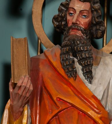 Zdjęcie nr 19: Ołtarz jednokondygnacyjny na wysokim, schodkowym cokole, trójosiowy, z wysuniętą mensą ołtarzową. Płyciny cokołu zdobione dekoracją w formie ostrołukowych maswerków i rozet w kwadratowej ramie. Antepedium flankowane parą kolumn ustawionych na wysokich cokołach i kanelowanych, skręconych trzonach z kompozytowymi kapitelami. W polu dwie prostokątne płyciny i kwadratowa pośrodku ze stylizowaną wicią roślinną i małą uskrzydloną główką aniołka. Tabernakulum proste, w kształcie prostopadłościennej skrzynki, o złotych drzwiczkach z wytłaczaną formą równoramiennego krzyża i wypukłą srebrną rybą oraz koszem z chlebem. Po obu stronach, na niewysokich postumentach dwa klęczące anioły z wysokimi skrzydłami, w biało różowych szatach z fioletowym podbiciem (skrzydła stylizowane na husarskie). Anioł po lewej z kadzielnicą, a anioł po prawej z kielichem.
Nastawa ołtarzowa o trzech oddzielnych niszach, nakrytych gotycyzującymi baldachimami z pinaklami, ozdobionymi żabkami. Oś środkowa w formie niszy zamkniętej ostrołukowo z wimpergą wspartą na smukłych, złoconych kolumienkach o kapitelach kompozytowych. Wimperga ze złoconymi, profilowanymi płycinami, zwieńczona rzeźbionymi liśćmi akantu i wolutami. Na przedłużeniu kolumn postumenty z figurami aniołów w biało niebieskich szatach, ze złotymi, wydłużonymi skrzydłami. Na osi na postumencie, pod gotycyzującym baldachimem figura świętego biskupa w czerwonej szacie z krzyżem w dłoni pomiędzy dwoma aniołami w białych i różowych szatach. W niszy, na czerwonym tle obraz Matki Boskiej Nieustającej Pomocy w prostej ramie z dekoracją w formie wici roślinnej. Poniżej dwa płaskorzeźbione anioły trzymające ażurowy monogram maryjny. Anioły o pozłacanych skrzydłach, na chmurach, w różowej i niebieskiej szacie. Osie boczne w formie aediculi z gotycyzującym baldachimem. W niszach figury, po lewej św. Piotra, a po prawej św. Pawła. Aedicule ujęte są smukłymi, skręconymi kolumnami z kapitelami wolutowymi oraz roślinnym uszakiem z perełkowaniem. Nad nimi imposty, na których rzeźby osłaniane baldachimami, po lewej świętego w habicie jezuity, a po prawej św. Jana Kantego. Drewno bejcowane na ciemny brąz, z nakładanymi elementami dekoracyjnymi złoconymi. 