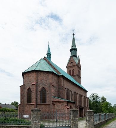 Zdjęcie nr 2: Kościół ceglany, na planie prostokąta z węższym i niższym prezbiterium z zakrystią od północy i wieżą od zachodu. Kościół orientowany, jednonawowy, czteroprzęsłowy z węższym, jednoprzęsłowym prezbiterium zamkniętym trójbocznie, z kruchtą w przyziemiu wieży. Nawa artykułowana półfilarami o ściętych narożach, przechodzącymi w zamknięte łukiem ostrym gurty krzyżowo-żebrowego sklepienia. W nawie i prezbiterium okna prostokątne zamknięte łukiem ostrym – pięć w prezbiterium, po trzy z każdej strony nawy. Węższe okna w przęśle chóru, kolejne w fasadzie. Główne wejście od wschodu, drugie od zachodu. Chór muzyczny w czwartym przęśle nawy, wsparty na wielobocznych filarach, podtrzymujących ostrołukowe arkady, z parapetem ozdobionym blendami. Ściany w dolnej partii pokryte drewnianą boazerią, wyżej malowane na kremowo, w partiach sklepienia polichromia podkreślająca elementy konstrukcji fragmentami stylizowanej wici i dekoracji floralnej; na belce tęczowej anioły niosące plakiety z symbolami świętych sakramentów. Fasada trójosiowa, z ryzalitem szerokości wieży oszkarpowanym na narożach. Podziały poziome przeprowadzone przy pomocy gzymsów. Na osi ostrołukowe wejście, powyżej wypełniony maswerkiem okulus. Następna kondygnacja jest częścią czworobocznej wieży, wypełniono ją dużym oknem w kształcę stojącego prostokąta zamkniętego łukiem ostrym.  Boczne osie z małymi oknami powtarzającymi kształt pozostałych, zamknięte trójkątnym przyczółkiem przerwanym na wieżę. Najwyższa kondygnacja wieży przepruta z każdej strony parą okien w kształcie stojących prostokątów umieszczonych w ostrołukowych niszach. Wieńczący ją gzyms dekorowany zygzakiem, powyżej trójkątne szczyty z ostrołukową blendą z okulusem w centrum. Elewacje boczne i prezbiterium oszkarpowane, przeprute oknami.  Hełm wieży w formie latarni zakończonej stożkiem z kupą i krzyżem, nawa przekryta dachem dwuspadowym, prezbiterium wielobocznym, zakrystia i wejście od zachodu pulpitowymi. 


Do najciekawszych elementów wyposażenia należą zespół neogotyckich ołtarzy wraz z amboną oraz kolekcja dziewiętnastowiecznych feretronów. W otoczeniu kościoła znajduje się kamienna figura św. Jana Nepomucena z 1788 roku. 
