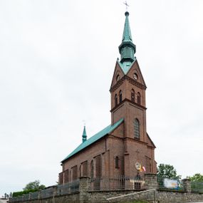 Zdjęcie nr 1: Kościół ceglany, na planie prostokąta z węższym i niższym prezbiterium z zakrystią od północy i wieżą od zachodu. Kościół orientowany, jednonawowy, czteroprzęsłowy z węższym, jednoprzęsłowym prezbiterium zamkniętym trójbocznie, z kruchtą w przyziemiu wieży. Nawa artykułowana półfilarami o ściętych narożach, przechodzącymi w zamknięte łukiem ostrym gurty krzyżowo-żebrowego sklepienia. W nawie i prezbiterium okna prostokątne zamknięte łukiem ostrym – pięć w prezbiterium, po trzy z każdej strony nawy. Węższe okna w przęśle chóru, kolejne w fasadzie. Główne wejście od wschodu, drugie od zachodu. Chór muzyczny w czwartym przęśle nawy, wsparty na wielobocznych filarach, podtrzymujących ostrołukowe arkady, z parapetem ozdobionym blendami. Ściany w dolnej partii pokryte drewnianą boazerią, wyżej malowane na kremowo, w partiach sklepienia polichromia podkreślająca elementy konstrukcji fragmentami stylizowanej wici i dekoracji floralnej; na belce tęczowej anioły niosące plakiety z symbolami świętych sakramentów. Fasada trójosiowa, z ryzalitem szerokości wieży oszkarpowanym na narożach. Podziały poziome przeprowadzone przy pomocy gzymsów. Na osi ostrołukowe wejście, powyżej wypełniony maswerkiem okulus. Następna kondygnacja jest częścią czworobocznej wieży, wypełniono ją dużym oknem w kształcę stojącego prostokąta zamkniętego łukiem ostrym.  Boczne osie z małymi oknami powtarzającymi kształt pozostałych, zamknięte trójkątnym przyczółkiem przerwanym na wieżę. Najwyższa kondygnacja wieży przepruta z każdej strony parą okien w kształcie stojących prostokątów umieszczonych w ostrołukowych niszach. Wieńczący ją gzyms dekorowany zygzakiem, powyżej trójkątne szczyty z ostrołukową blendą z okulusem w centrum. Elewacje boczne i prezbiterium oszkarpowane, przeprute oknami.  Hełm wieży w formie latarni zakończonej stożkiem z kupą i krzyżem, nawa przekryta dachem dwuspadowym, prezbiterium wielobocznym, zakrystia i wejście od zachodu pulpitowymi. 


Do najciekawszych elementów wyposażenia należą zespół neogotyckich ołtarzy wraz z amboną oraz kolekcja dziewiętnastowiecznych feretronów. W otoczeniu kościoła znajduje się kamienna figura św. Jana Nepomucena z 1788 roku. 
