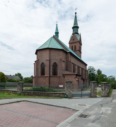 Zdjęcie nr 45: Kościół ceglany, na planie prostokąta z węższym i niższym prezbiterium z zakrystią od północy i wieżą od zachodu. Kościół orientowany, jednonawowy, czteroprzęsłowy z węższym, jednoprzęsłowym prezbiterium zamkniętym trójbocznie, z kruchtą w przyziemiu wieży. Nawa artykułowana półfilarami o ściętych narożach, przechodzącymi w zamknięte łukiem ostrym gurty krzyżowo-żebrowego sklepienia. W nawie i prezbiterium okna prostokątne zamknięte łukiem ostrym – pięć w prezbiterium, po trzy z każdej strony nawy. Węższe okna w przęśle chóru, kolejne w fasadzie. Główne wejście od wschodu, drugie od zachodu. Chór muzyczny w czwartym przęśle nawy, wsparty na wielobocznych filarach, podtrzymujących ostrołukowe arkady, z parapetem ozdobionym blendami. Ściany w dolnej partii pokryte drewnianą boazerią, wyżej malowane na kremowo, w partiach sklepienia polichromia podkreślająca elementy konstrukcji fragmentami stylizowanej wici i dekoracji floralnej; na belce tęczowej anioły niosące plakiety z symbolami świętych sakramentów. Fasada trójosiowa, z ryzalitem szerokości wieży oszkarpowanym na narożach. Podziały poziome przeprowadzone przy pomocy gzymsów. Na osi ostrołukowe wejście, powyżej wypełniony maswerkiem okulus. Następna kondygnacja jest częścią czworobocznej wieży, wypełniono ją dużym oknem w kształcę stojącego prostokąta zamkniętego łukiem ostrym.  Boczne osie z małymi oknami powtarzającymi kształt pozostałych, zamknięte trójkątnym przyczółkiem przerwanym na wieżę. Najwyższa kondygnacja wieży przepruta z każdej strony parą okien w kształcie stojących prostokątów umieszczonych w ostrołukowych niszach. Wieńczący ją gzyms dekorowany zygzakiem, powyżej trójkątne szczyty z ostrołukową blendą z okulusem w centrum. Elewacje boczne i prezbiterium oszkarpowane, przeprute oknami.  Hełm wieży w formie latarni zakończonej stożkiem z kupą i krzyżem, nawa przekryta dachem dwuspadowym, prezbiterium wielobocznym, zakrystia i wejście od zachodu pulpitowymi. 


Do najciekawszych elementów wyposażenia należą zespół neogotyckich ołtarzy wraz z amboną oraz kolekcja dziewiętnastowiecznych feretronów. W otoczeniu kościoła znajduje się kamienna figura św. Jana Nepomucena z 1788 roku. 
