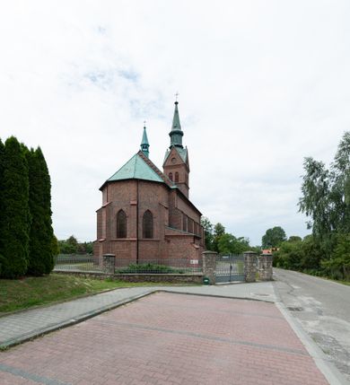 Zdjęcie nr 46: Kościół ceglany, na planie prostokąta z węższym i niższym prezbiterium z zakrystią od północy i wieżą od zachodu. Kościół orientowany, jednonawowy, czteroprzęsłowy z węższym, jednoprzęsłowym prezbiterium zamkniętym trójbocznie, z kruchtą w przyziemiu wieży. Nawa artykułowana półfilarami o ściętych narożach, przechodzącymi w zamknięte łukiem ostrym gurty krzyżowo-żebrowego sklepienia. W nawie i prezbiterium okna prostokątne zamknięte łukiem ostrym – pięć w prezbiterium, po trzy z każdej strony nawy. Węższe okna w przęśle chóru, kolejne w fasadzie. Główne wejście od wschodu, drugie od zachodu. Chór muzyczny w czwartym przęśle nawy, wsparty na wielobocznych filarach, podtrzymujących ostrołukowe arkady, z parapetem ozdobionym blendami. Ściany w dolnej partii pokryte drewnianą boazerią, wyżej malowane na kremowo, w partiach sklepienia polichromia podkreślająca elementy konstrukcji fragmentami stylizowanej wici i dekoracji floralnej; na belce tęczowej anioły niosące plakiety z symbolami świętych sakramentów. Fasada trójosiowa, z ryzalitem szerokości wieży oszkarpowanym na narożach. Podziały poziome przeprowadzone przy pomocy gzymsów. Na osi ostrołukowe wejście, powyżej wypełniony maswerkiem okulus. Następna kondygnacja jest częścią czworobocznej wieży, wypełniono ją dużym oknem w kształcę stojącego prostokąta zamkniętego łukiem ostrym.  Boczne osie z małymi oknami powtarzającymi kształt pozostałych, zamknięte trójkątnym przyczółkiem przerwanym na wieżę. Najwyższa kondygnacja wieży przepruta z każdej strony parą okien w kształcie stojących prostokątów umieszczonych w ostrołukowych niszach. Wieńczący ją gzyms dekorowany zygzakiem, powyżej trójkątne szczyty z ostrołukową blendą z okulusem w centrum. Elewacje boczne i prezbiterium oszkarpowane, przeprute oknami.  Hełm wieży w formie latarni zakończonej stożkiem z kupą i krzyżem, nawa przekryta dachem dwuspadowym, prezbiterium wielobocznym, zakrystia i wejście od zachodu pulpitowymi. 


Do najciekawszych elementów wyposażenia należą zespół neogotyckich ołtarzy wraz z amboną oraz kolekcja dziewiętnastowiecznych feretronów. W otoczeniu kościoła znajduje się kamienna figura św. Jana Nepomucena z 1788 roku. 
