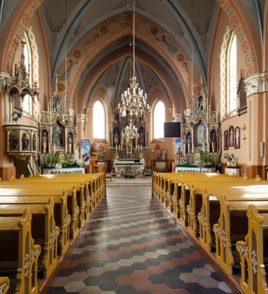 Zdjęcie nr 19: Kościół ceglany, na planie prostokąta z węższym i niższym prezbiterium z zakrystią od północy i wieżą od zachodu. Kościół orientowany, jednonawowy, czteroprzęsłowy z węższym, jednoprzęsłowym prezbiterium zamkniętym trójbocznie, z kruchtą w przyziemiu wieży. Nawa artykułowana półfilarami o ściętych narożach, przechodzącymi w zamknięte łukiem ostrym gurty krzyżowo-żebrowego sklepienia. W nawie i prezbiterium okna prostokątne zamknięte łukiem ostrym – pięć w prezbiterium, po trzy z każdej strony nawy. Węższe okna w przęśle chóru, kolejne w fasadzie. Główne wejście od wschodu, drugie od zachodu. Chór muzyczny w czwartym przęśle nawy, wsparty na wielobocznych filarach, podtrzymujących ostrołukowe arkady, z parapetem ozdobionym blendami. Ściany w dolnej partii pokryte drewnianą boazerią, wyżej malowane na kremowo, w partiach sklepienia polichromia podkreślająca elementy konstrukcji fragmentami stylizowanej wici i dekoracji floralnej; na belce tęczowej anioły niosące plakiety z symbolami świętych sakramentów. Fasada trójosiowa, z ryzalitem szerokości wieży oszkarpowanym na narożach. Podziały poziome przeprowadzone przy pomocy gzymsów. Na osi ostrołukowe wejście, powyżej wypełniony maswerkiem okulus. Następna kondygnacja jest częścią czworobocznej wieży, wypełniono ją dużym oknem w kształcę stojącego prostokąta zamkniętego łukiem ostrym.  Boczne osie z małymi oknami powtarzającymi kształt pozostałych, zamknięte trójkątnym przyczółkiem przerwanym na wieżę. Najwyższa kondygnacja wieży przepruta z każdej strony parą okien w kształcie stojących prostokątów umieszczonych w ostrołukowych niszach. Wieńczący ją gzyms dekorowany zygzakiem, powyżej trójkątne szczyty z ostrołukową blendą z okulusem w centrum. Elewacje boczne i prezbiterium oszkarpowane, przeprute oknami.  Hełm wieży w formie latarni zakończonej stożkiem z kupą i krzyżem, nawa przekryta dachem dwuspadowym, prezbiterium wielobocznym, zakrystia i wejście od zachodu pulpitowymi. 


Do najciekawszych elementów wyposażenia należą zespół neogotyckich ołtarzy wraz z amboną oraz kolekcja dziewiętnastowiecznych feretronów. W otoczeniu kościoła znajduje się kamienna figura św. Jana Nepomucena z 1788 roku. 
