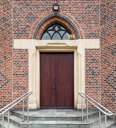 Zdjęcie nr 10: Kościół ceglany, na planie prostokąta z węższym i niższym prezbiterium z zakrystią od północy i wieżą od zachodu. Kościół orientowany, jednonawowy, czteroprzęsłowy z węższym, jednoprzęsłowym prezbiterium zamkniętym trójbocznie, z kruchtą w przyziemiu wieży. Nawa artykułowana półfilarami o ściętych narożach, przechodzącymi w zamknięte łukiem ostrym gurty krzyżowo-żebrowego sklepienia. W nawie i prezbiterium okna prostokątne zamknięte łukiem ostrym – pięć w prezbiterium, po trzy z każdej strony nawy. Węższe okna w przęśle chóru, kolejne w fasadzie. Główne wejście od wschodu, drugie od zachodu. Chór muzyczny w czwartym przęśle nawy, wsparty na wielobocznych filarach, podtrzymujących ostrołukowe arkady, z parapetem ozdobionym blendami. Ściany w dolnej partii pokryte drewnianą boazerią, wyżej malowane na kremowo, w partiach sklepienia polichromia podkreślająca elementy konstrukcji fragmentami stylizowanej wici i dekoracji floralnej; na belce tęczowej anioły niosące plakiety z symbolami świętych sakramentów. Fasada trójosiowa, z ryzalitem szerokości wieży oszkarpowanym na narożach. Podziały poziome przeprowadzone przy pomocy gzymsów. Na osi ostrołukowe wejście, powyżej wypełniony maswerkiem okulus. Następna kondygnacja jest częścią czworobocznej wieży, wypełniono ją dużym oknem w kształcę stojącego prostokąta zamkniętego łukiem ostrym.  Boczne osie z małymi oknami powtarzającymi kształt pozostałych, zamknięte trójkątnym przyczółkiem przerwanym na wieżę. Najwyższa kondygnacja wieży przepruta z każdej strony parą okien w kształcie stojących prostokątów umieszczonych w ostrołukowych niszach. Wieńczący ją gzyms dekorowany zygzakiem, powyżej trójkątne szczyty z ostrołukową blendą z okulusem w centrum. Elewacje boczne i prezbiterium oszkarpowane, przeprute oknami.  Hełm wieży w formie latarni zakończonej stożkiem z kupą i krzyżem, nawa przekryta dachem dwuspadowym, prezbiterium wielobocznym, zakrystia i wejście od zachodu pulpitowymi. 


Do najciekawszych elementów wyposażenia należą zespół neogotyckich ołtarzy wraz z amboną oraz kolekcja dziewiętnastowiecznych feretronów. W otoczeniu kościoła znajduje się kamienna figura św. Jana Nepomucena z 1788 roku. 
