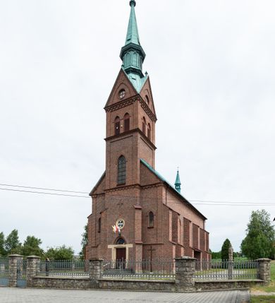 Zdjęcie nr 16: Kościół ceglany, na planie prostokąta z węższym i niższym prezbiterium z zakrystią od północy i wieżą od zachodu. Kościół orientowany, jednonawowy, czteroprzęsłowy z węższym, jednoprzęsłowym prezbiterium zamkniętym trójbocznie, z kruchtą w przyziemiu wieży. Nawa artykułowana półfilarami o ściętych narożach, przechodzącymi w zamknięte łukiem ostrym gurty krzyżowo-żebrowego sklepienia. W nawie i prezbiterium okna prostokątne zamknięte łukiem ostrym – pięć w prezbiterium, po trzy z każdej strony nawy. Węższe okna w przęśle chóru, kolejne w fasadzie. Główne wejście od wschodu, drugie od zachodu. Chór muzyczny w czwartym przęśle nawy, wsparty na wielobocznych filarach, podtrzymujących ostrołukowe arkady, z parapetem ozdobionym blendami. Ściany w dolnej partii pokryte drewnianą boazerią, wyżej malowane na kremowo, w partiach sklepienia polichromia podkreślająca elementy konstrukcji fragmentami stylizowanej wici i dekoracji floralnej; na belce tęczowej anioły niosące plakiety z symbolami świętych sakramentów. Fasada trójosiowa, z ryzalitem szerokości wieży oszkarpowanym na narożach. Podziały poziome przeprowadzone przy pomocy gzymsów. Na osi ostrołukowe wejście, powyżej wypełniony maswerkiem okulus. Następna kondygnacja jest częścią czworobocznej wieży, wypełniono ją dużym oknem w kształcę stojącego prostokąta zamkniętego łukiem ostrym.  Boczne osie z małymi oknami powtarzającymi kształt pozostałych, zamknięte trójkątnym przyczółkiem przerwanym na wieżę. Najwyższa kondygnacja wieży przepruta z każdej strony parą okien w kształcie stojących prostokątów umieszczonych w ostrołukowych niszach. Wieńczący ją gzyms dekorowany zygzakiem, powyżej trójkątne szczyty z ostrołukową blendą z okulusem w centrum. Elewacje boczne i prezbiterium oszkarpowane, przeprute oknami.  Hełm wieży w formie latarni zakończonej stożkiem z kupą i krzyżem, nawa przekryta dachem dwuspadowym, prezbiterium wielobocznym, zakrystia i wejście od zachodu pulpitowymi. 


Do najciekawszych elementów wyposażenia należą zespół neogotyckich ołtarzy wraz z amboną oraz kolekcja dziewiętnastowiecznych feretronów. W otoczeniu kościoła znajduje się kamienna figura św. Jana Nepomucena z 1788 roku. 

