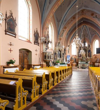 Zdjęcie nr 23: Kościół ceglany, na planie prostokąta z węższym i niższym prezbiterium z zakrystią od północy i wieżą od zachodu. Kościół orientowany, jednonawowy, czteroprzęsłowy z węższym, jednoprzęsłowym prezbiterium zamkniętym trójbocznie, z kruchtą w przyziemiu wieży. Nawa artykułowana półfilarami o ściętych narożach, przechodzącymi w zamknięte łukiem ostrym gurty krzyżowo-żebrowego sklepienia. W nawie i prezbiterium okna prostokątne zamknięte łukiem ostrym – pięć w prezbiterium, po trzy z każdej strony nawy. Węższe okna w przęśle chóru, kolejne w fasadzie. Główne wejście od wschodu, drugie od zachodu. Chór muzyczny w czwartym przęśle nawy, wsparty na wielobocznych filarach, podtrzymujących ostrołukowe arkady, z parapetem ozdobionym blendami. Ściany w dolnej partii pokryte drewnianą boazerią, wyżej malowane na kremowo, w partiach sklepienia polichromia podkreślająca elementy konstrukcji fragmentami stylizowanej wici i dekoracji floralnej; na belce tęczowej anioły niosące plakiety z symbolami świętych sakramentów. Fasada trójosiowa, z ryzalitem szerokości wieży oszkarpowanym na narożach. Podziały poziome przeprowadzone przy pomocy gzymsów. Na osi ostrołukowe wejście, powyżej wypełniony maswerkiem okulus. Następna kondygnacja jest częścią czworobocznej wieży, wypełniono ją dużym oknem w kształcę stojącego prostokąta zamkniętego łukiem ostrym.  Boczne osie z małymi oknami powtarzającymi kształt pozostałych, zamknięte trójkątnym przyczółkiem przerwanym na wieżę. Najwyższa kondygnacja wieży przepruta z każdej strony parą okien w kształcie stojących prostokątów umieszczonych w ostrołukowych niszach. Wieńczący ją gzyms dekorowany zygzakiem, powyżej trójkątne szczyty z ostrołukową blendą z okulusem w centrum. Elewacje boczne i prezbiterium oszkarpowane, przeprute oknami.  Hełm wieży w formie latarni zakończonej stożkiem z kupą i krzyżem, nawa przekryta dachem dwuspadowym, prezbiterium wielobocznym, zakrystia i wejście od zachodu pulpitowymi. 


Do najciekawszych elementów wyposażenia należą zespół neogotyckich ołtarzy wraz z amboną oraz kolekcja dziewiętnastowiecznych feretronów. W otoczeniu kościoła znajduje się kamienna figura św. Jana Nepomucena z 1788 roku. 
