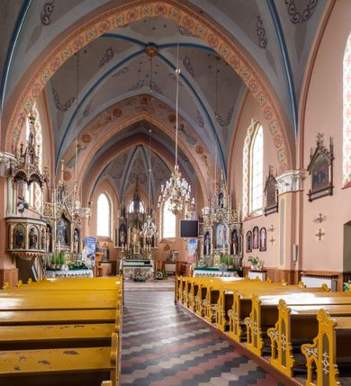 Zdjęcie nr 25: Kościół ceglany, na planie prostokąta z węższym i niższym prezbiterium z zakrystią od północy i wieżą od zachodu. Kościół orientowany, jednonawowy, czteroprzęsłowy z węższym, jednoprzęsłowym prezbiterium zamkniętym trójbocznie, z kruchtą w przyziemiu wieży. Nawa artykułowana półfilarami o ściętych narożach, przechodzącymi w zamknięte łukiem ostrym gurty krzyżowo-żebrowego sklepienia. W nawie i prezbiterium okna prostokątne zamknięte łukiem ostrym – pięć w prezbiterium, po trzy z każdej strony nawy. Węższe okna w przęśle chóru, kolejne w fasadzie. Główne wejście od wschodu, drugie od zachodu. Chór muzyczny w czwartym przęśle nawy, wsparty na wielobocznych filarach, podtrzymujących ostrołukowe arkady, z parapetem ozdobionym blendami. Ściany w dolnej partii pokryte drewnianą boazerią, wyżej malowane na kremowo, w partiach sklepienia polichromia podkreślająca elementy konstrukcji fragmentami stylizowanej wici i dekoracji floralnej; na belce tęczowej anioły niosące plakiety z symbolami świętych sakramentów. Fasada trójosiowa, z ryzalitem szerokości wieży oszkarpowanym na narożach. Podziały poziome przeprowadzone przy pomocy gzymsów. Na osi ostrołukowe wejście, powyżej wypełniony maswerkiem okulus. Następna kondygnacja jest częścią czworobocznej wieży, wypełniono ją dużym oknem w kształcę stojącego prostokąta zamkniętego łukiem ostrym.  Boczne osie z małymi oknami powtarzającymi kształt pozostałych, zamknięte trójkątnym przyczółkiem przerwanym na wieżę. Najwyższa kondygnacja wieży przepruta z każdej strony parą okien w kształcie stojących prostokątów umieszczonych w ostrołukowych niszach. Wieńczący ją gzyms dekorowany zygzakiem, powyżej trójkątne szczyty z ostrołukową blendą z okulusem w centrum. Elewacje boczne i prezbiterium oszkarpowane, przeprute oknami.  Hełm wieży w formie latarni zakończonej stożkiem z kupą i krzyżem, nawa przekryta dachem dwuspadowym, prezbiterium wielobocznym, zakrystia i wejście od zachodu pulpitowymi. 


Do najciekawszych elementów wyposażenia należą zespół neogotyckich ołtarzy wraz z amboną oraz kolekcja dziewiętnastowiecznych feretronów. W otoczeniu kościoła znajduje się kamienna figura św. Jana Nepomucena z 1788 roku. 
